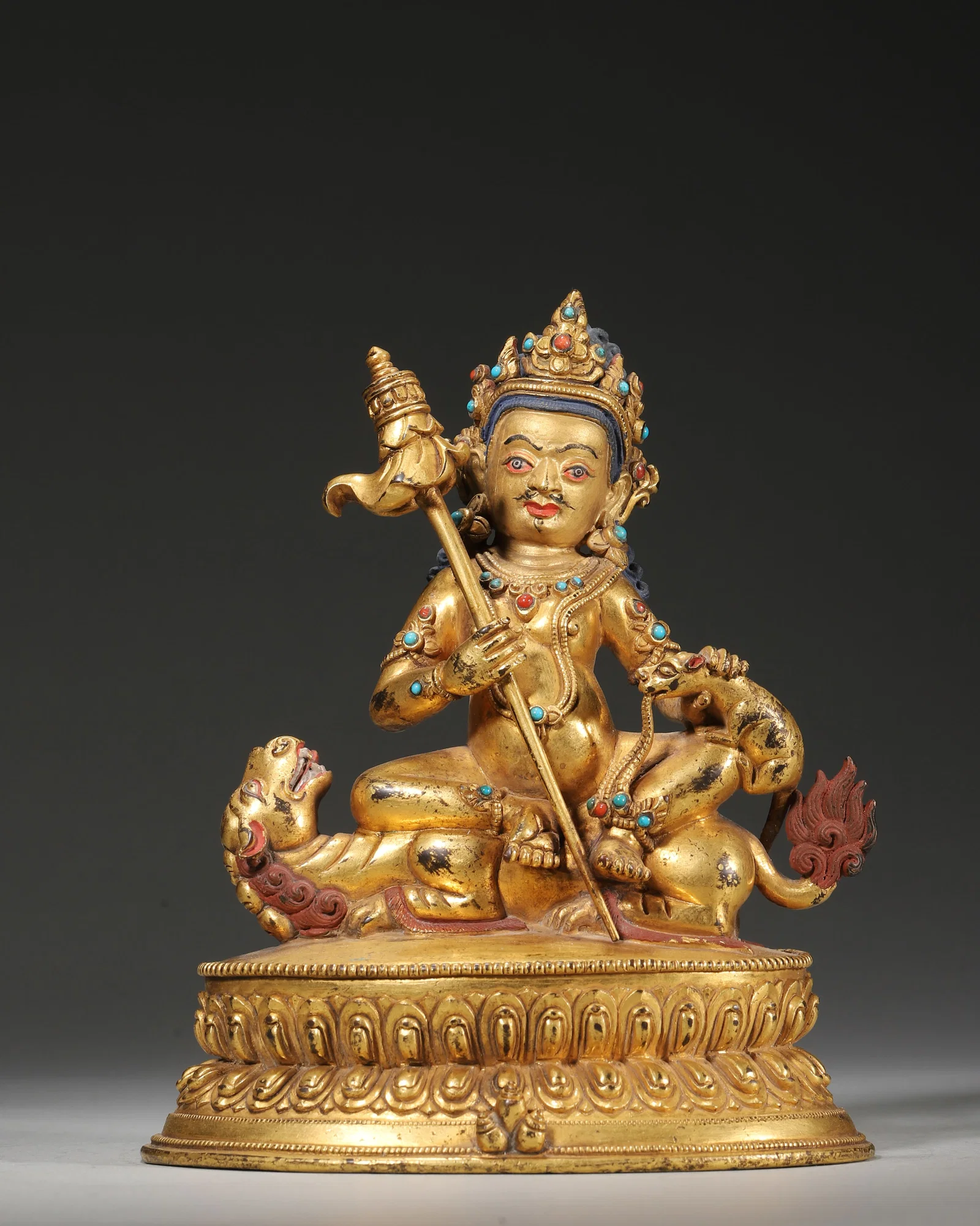 18TH–19TH CENTURY GILT-COPPER INLAID GEMSTONE STATUE OF JAMBHALA ON LION THRONE