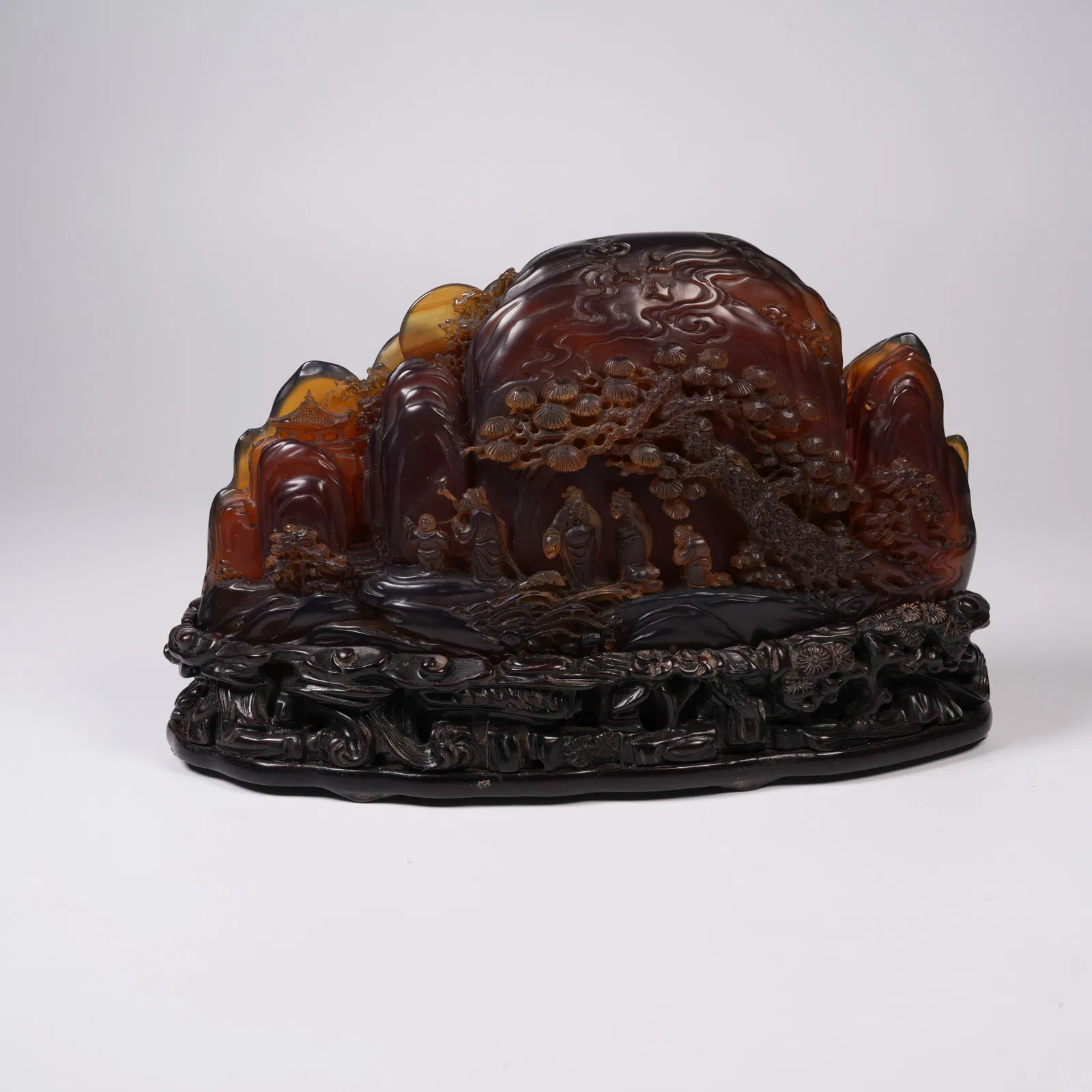 A AMBER MINIATURE ORNAMENT WITH SCHOLAR UNDER PINE MOTIF