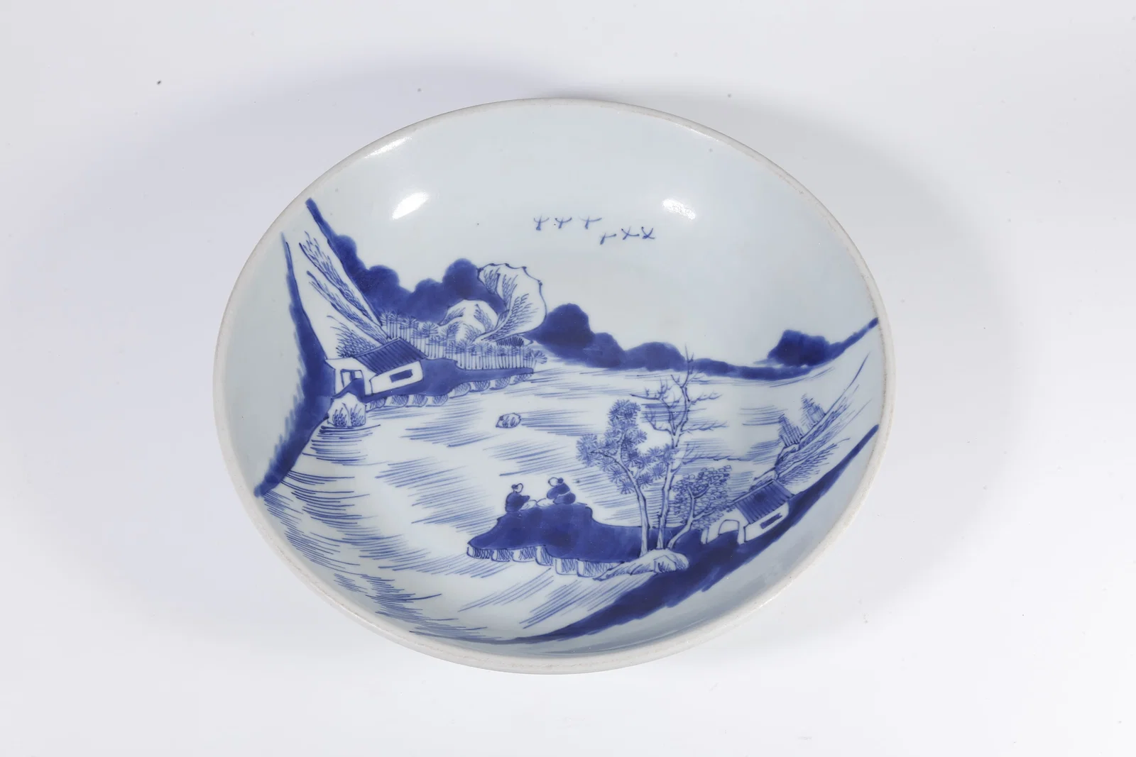 A BLUE-AND-WHITE PLATE WITH LANDSCAPE AND FIGURE DECORATION