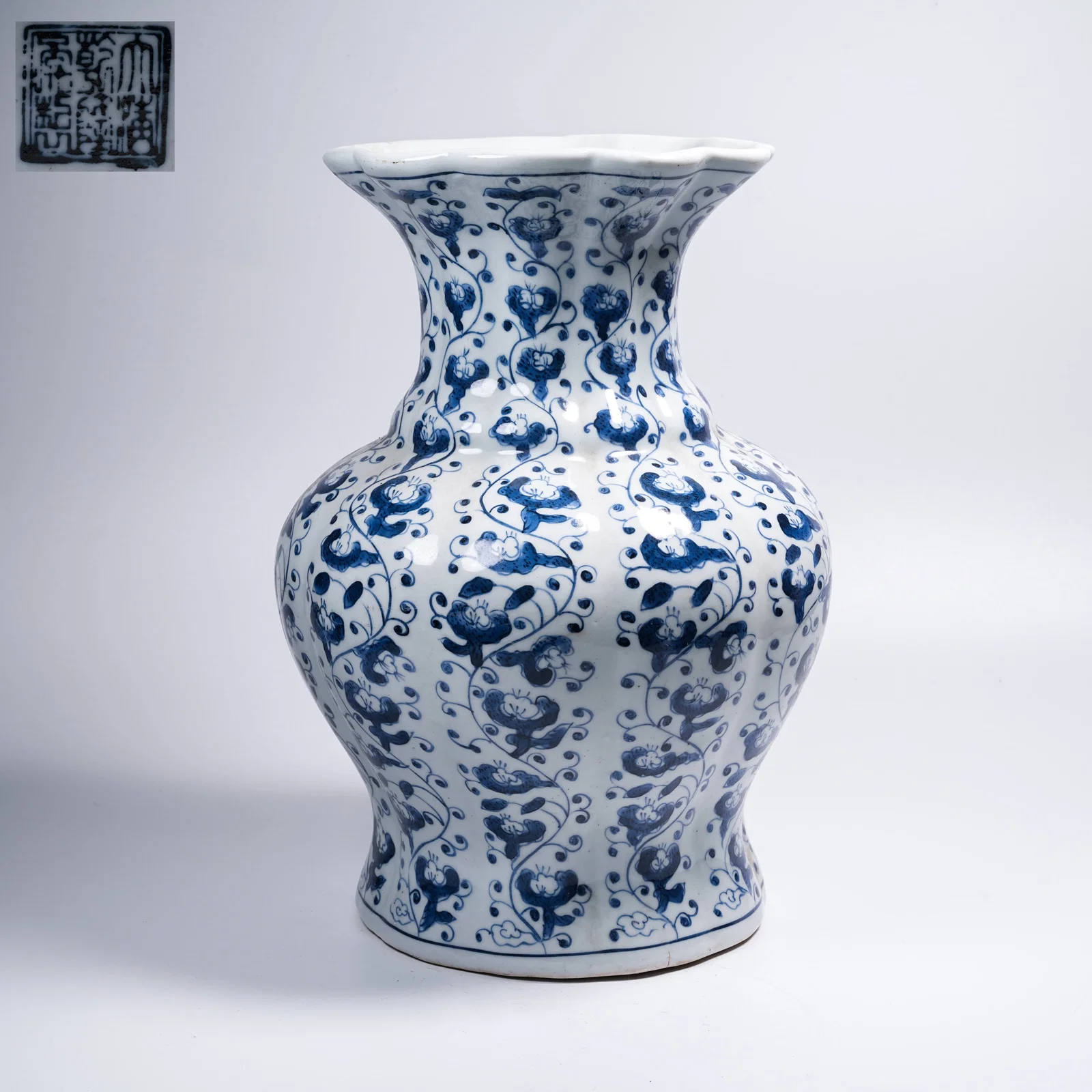 A BLUE-AND-WHITE POMEGRANATE-SHAPED ZUN WITH FLORAL MOTIFS AND FOLIATED RIM