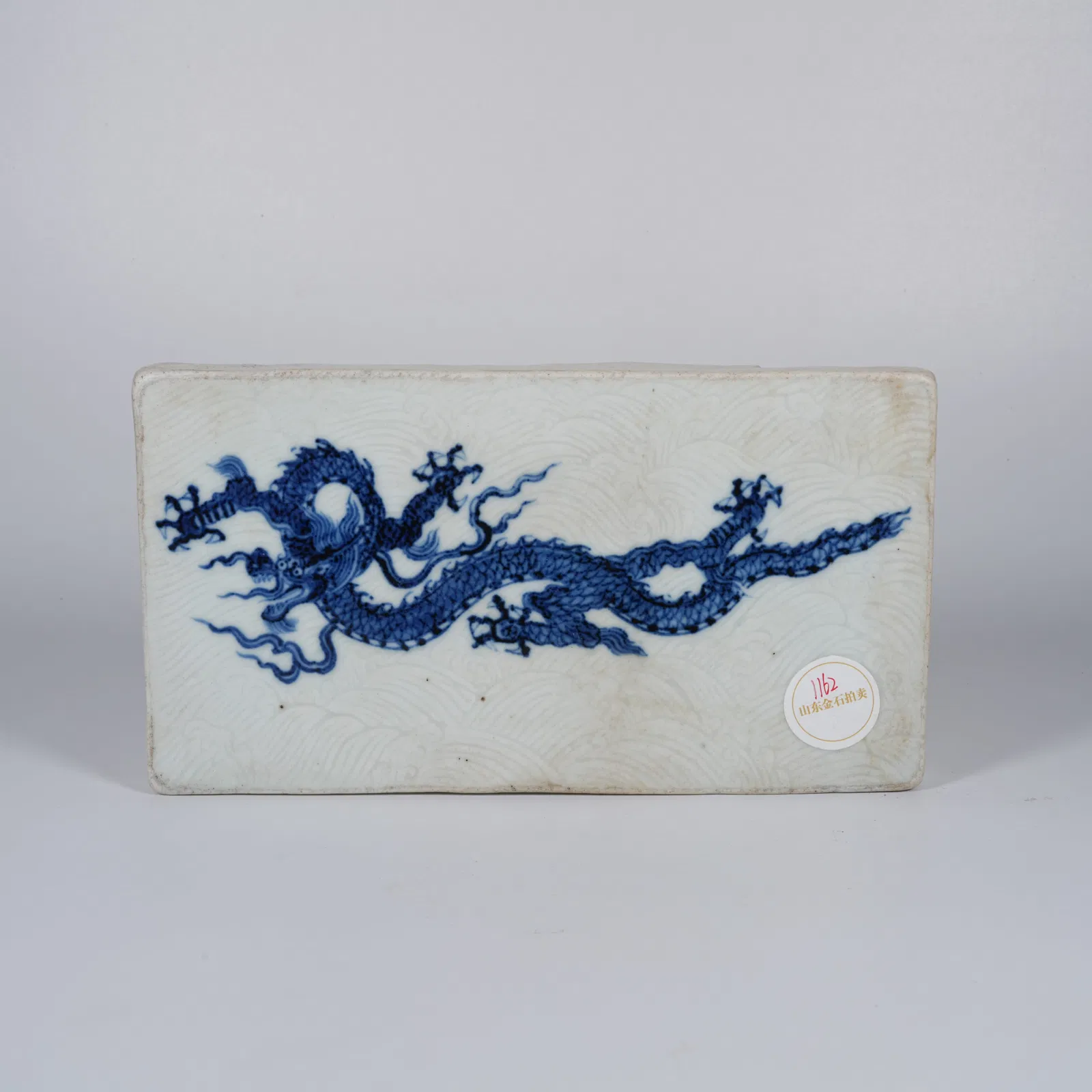 A BLUE-AND-WHITE PORCELAIN PLAQUE WITH SEA-AND-DRAGON MOTIF