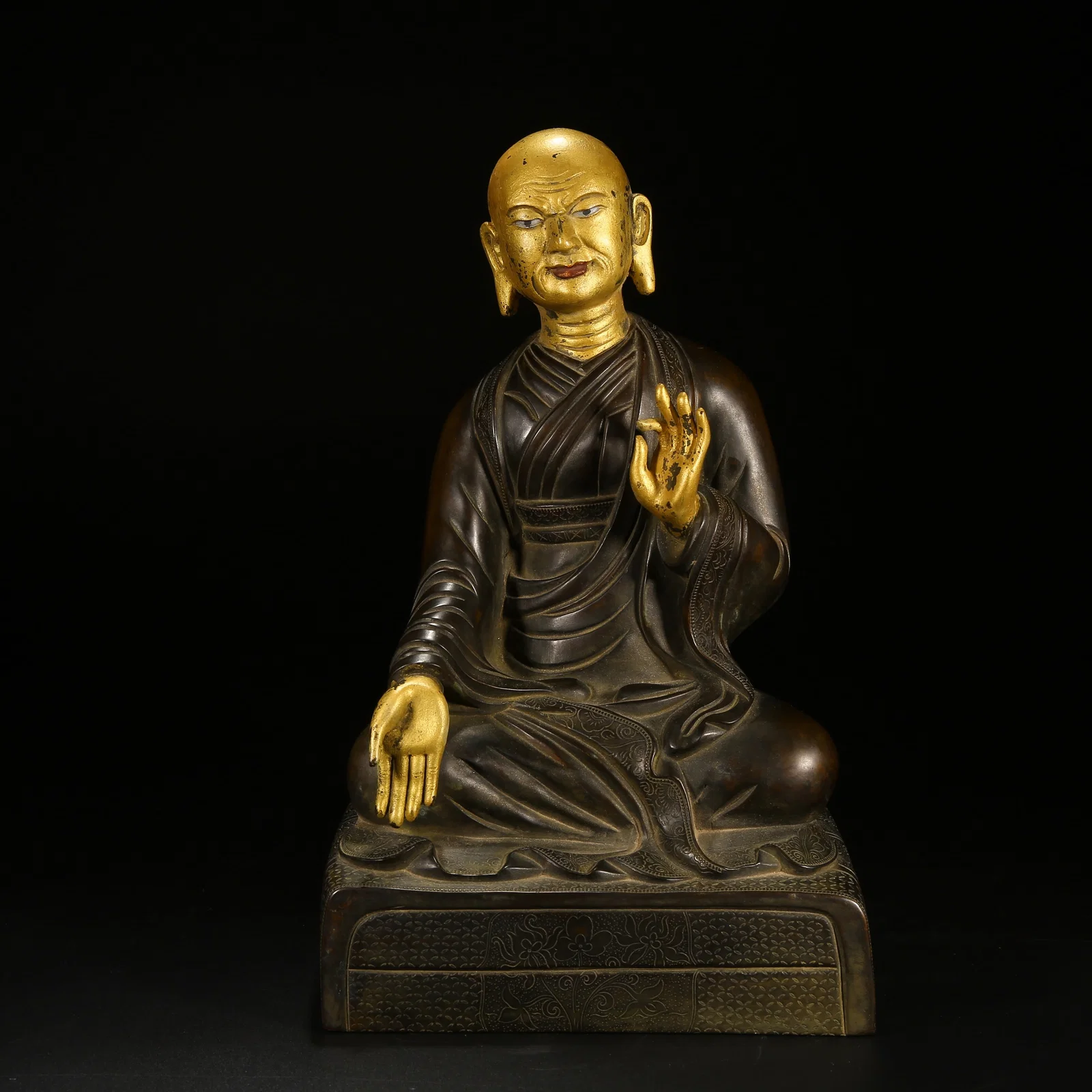 A BRONZE ARHAT STATUE WITH PARTIAL GILT DECORATION