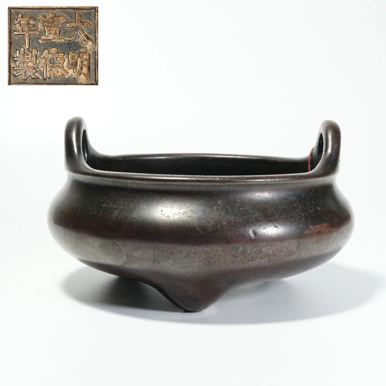 A BRONZE CENSER WITH UPTURNED HANDLES