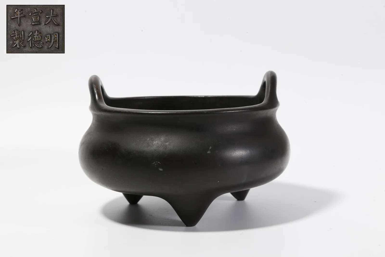 A BRONZE DOUBLE-BRIDGE-HANDLED THREE-LEGGED INCENSE BURNER