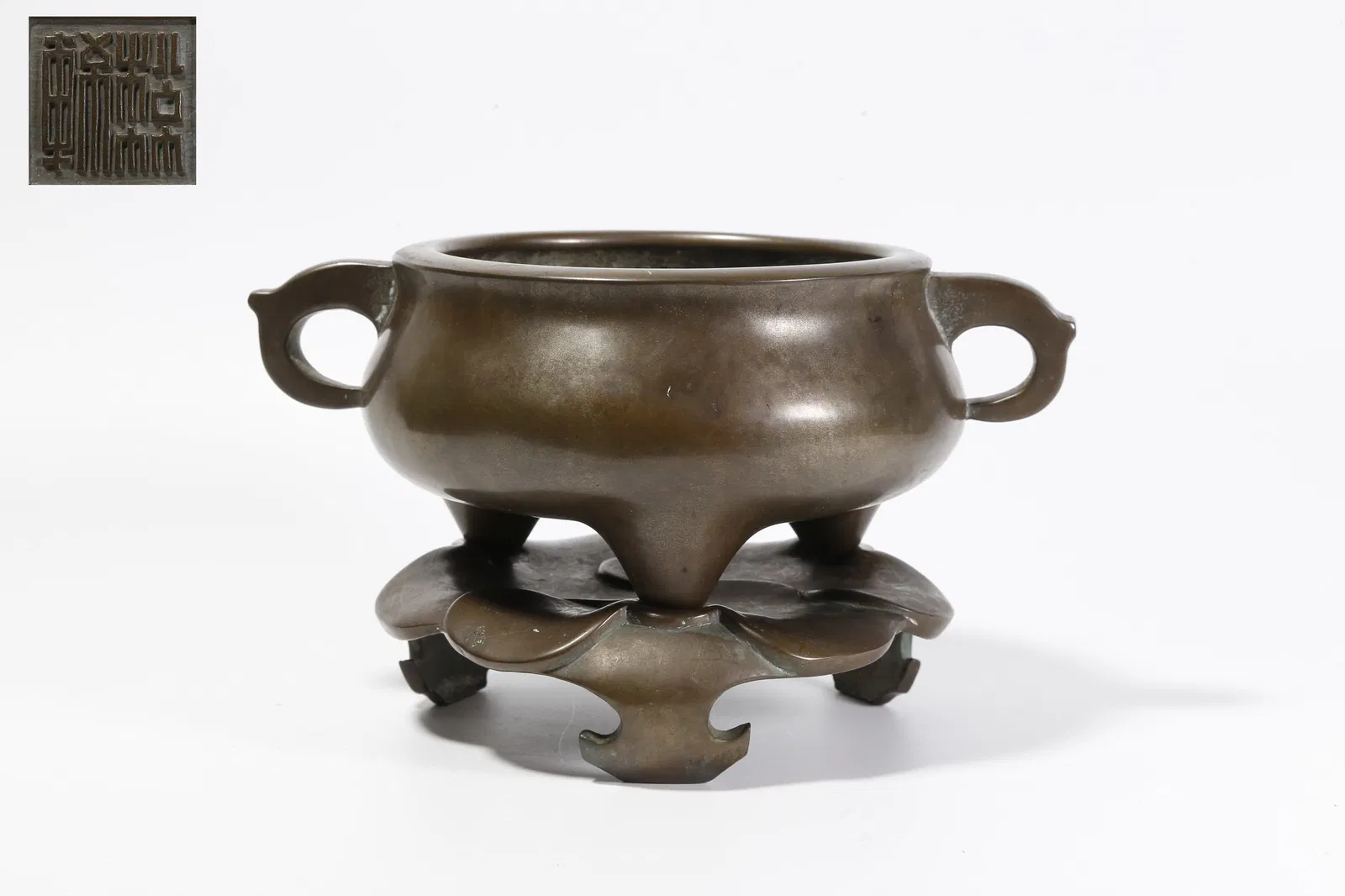 A BRONZE DOUBLE-HANDLED THREE-LEGGED INCENSE BURNER