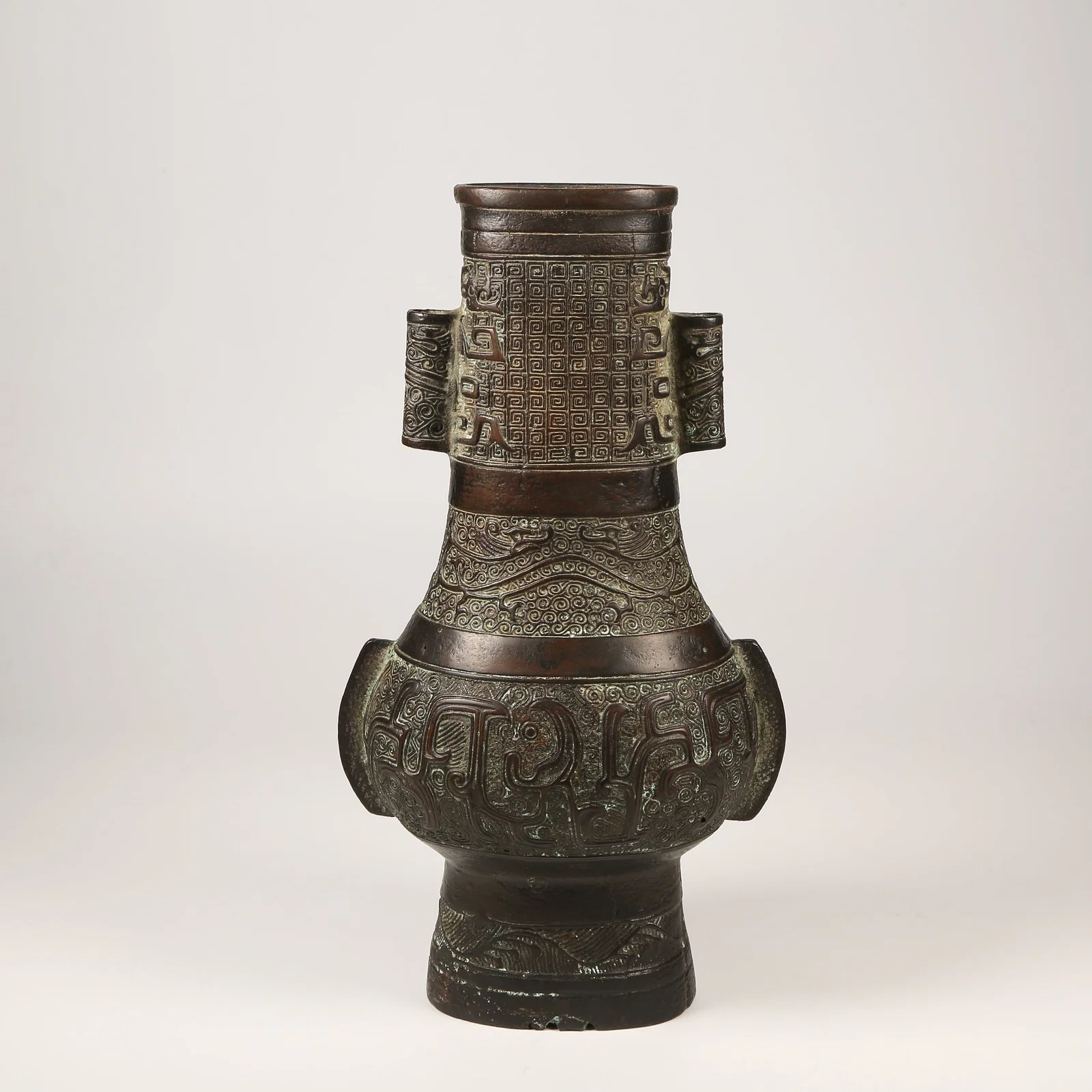 A BRONZE EWER WITH DRAGON MOTIFS AND UPRIGHT FINIALS, ANIMAL-FORM HANDLES