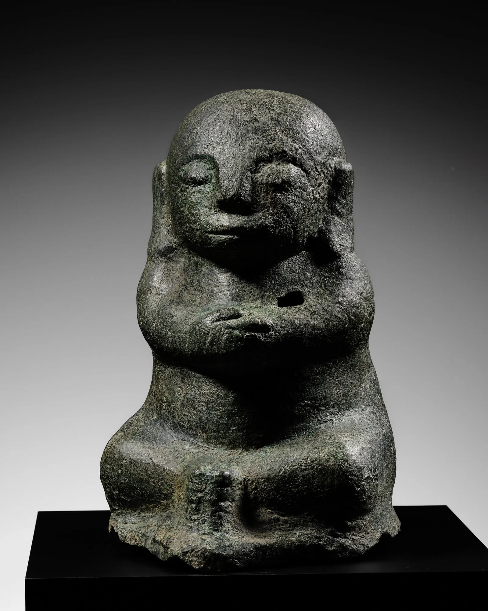 A BRONZE FIGURE OF A SEATED MALE DEITY, GOA MADE, EAST JAVA, INDONESIA, 1ST MILLENNIUM BC-1ST
