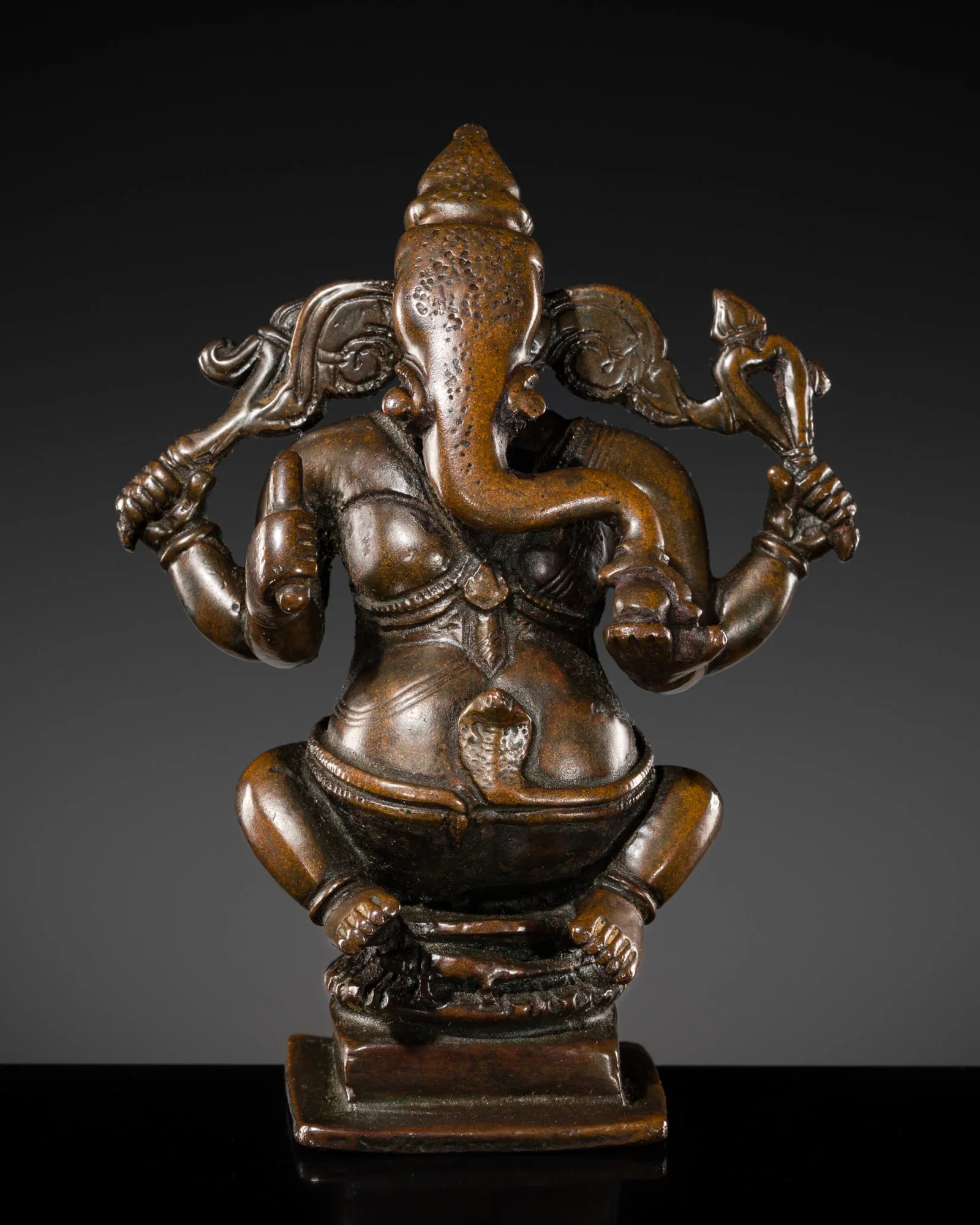 A BRONZE FIGURE OF GANESHA, SOUTH INDIA, 17TH-18TH CENTURY