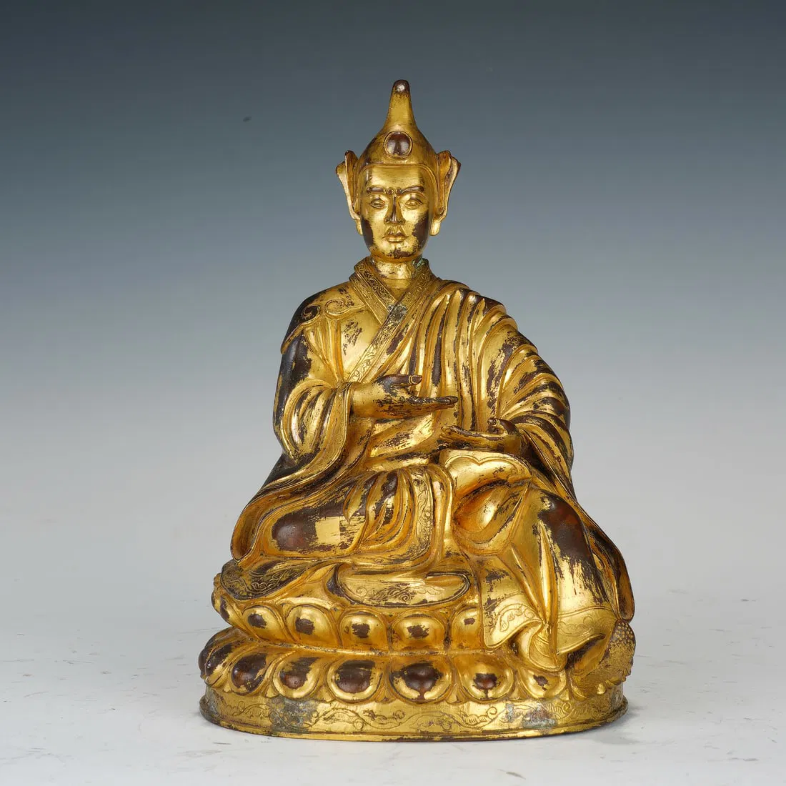 A BRONZE-GILT FIGURE OF LAMA