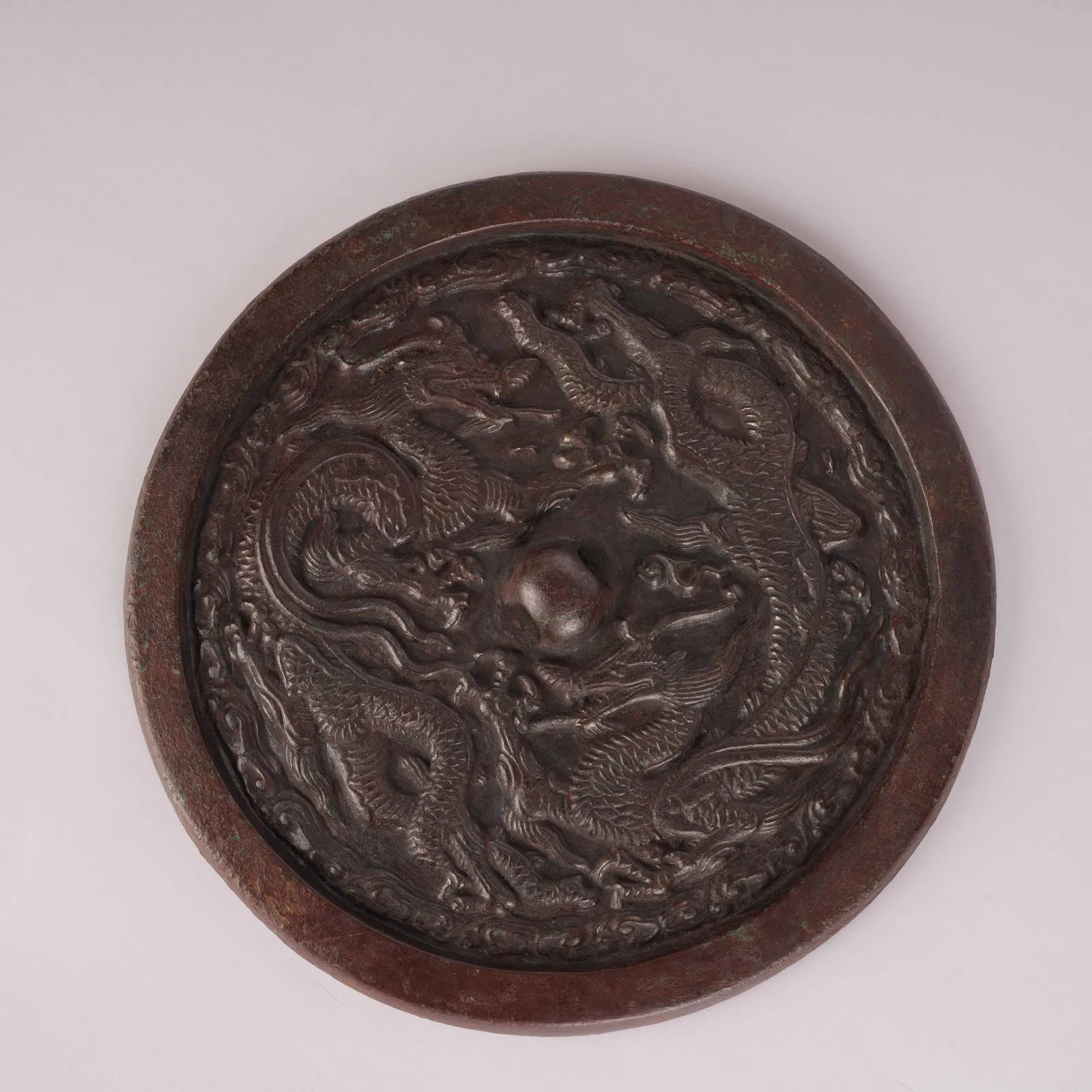 A BRONZE MIRROR WITH TWIN DRAGON DESIGN, JIN DYNASTY
