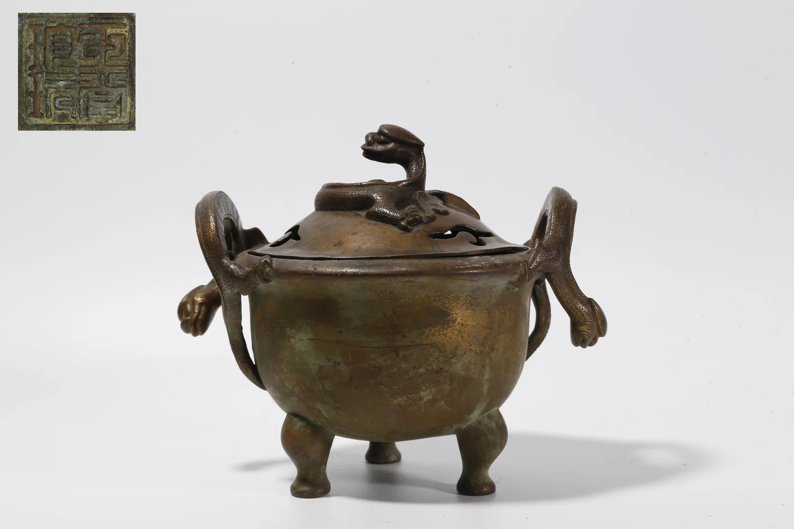 A BRONZE THREE-LEGGED CENSER WITH DRAGON KNOB