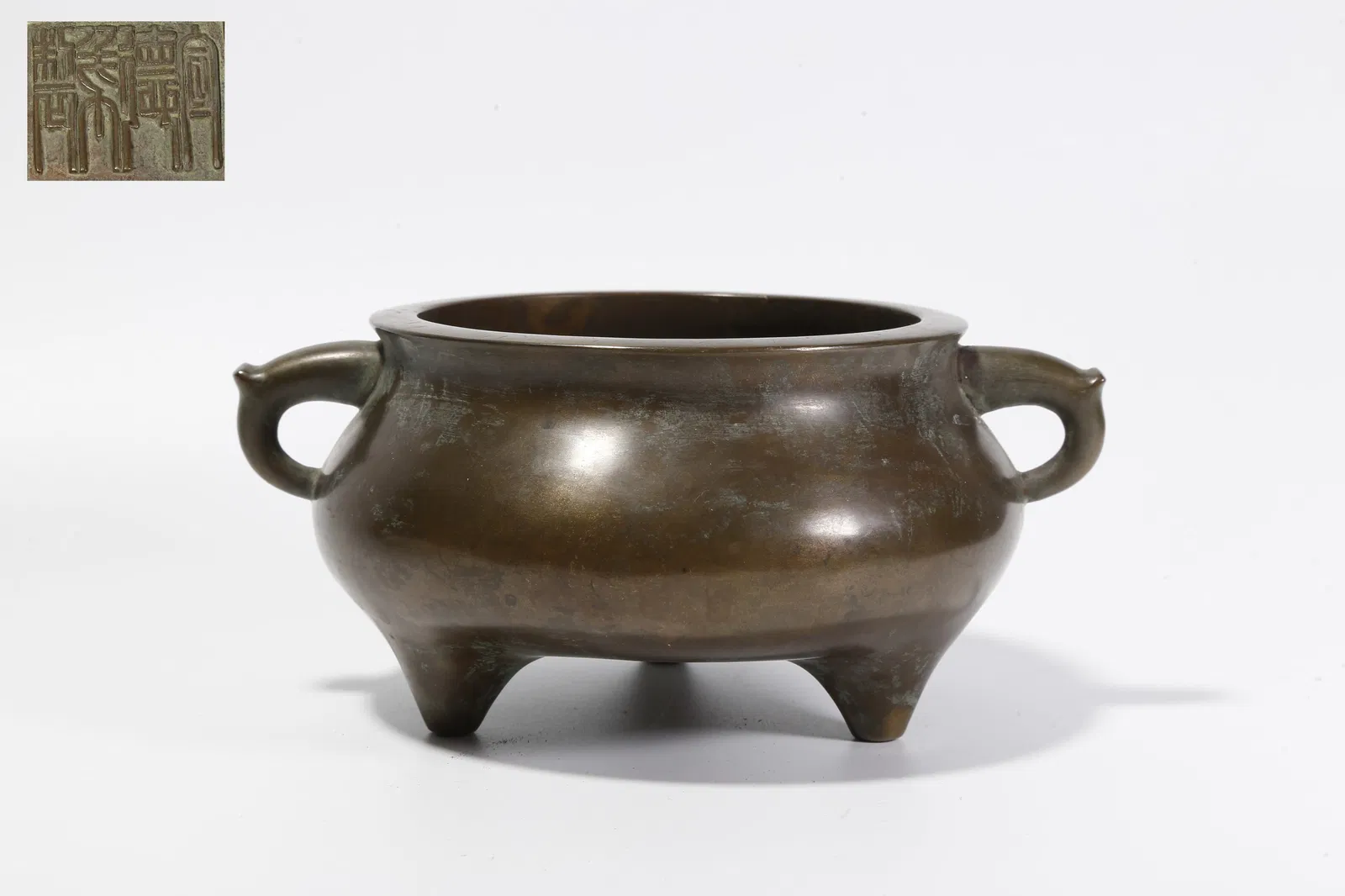 A BRONZE THREE-LEGGED DOUBLE-HANDLED CENSER