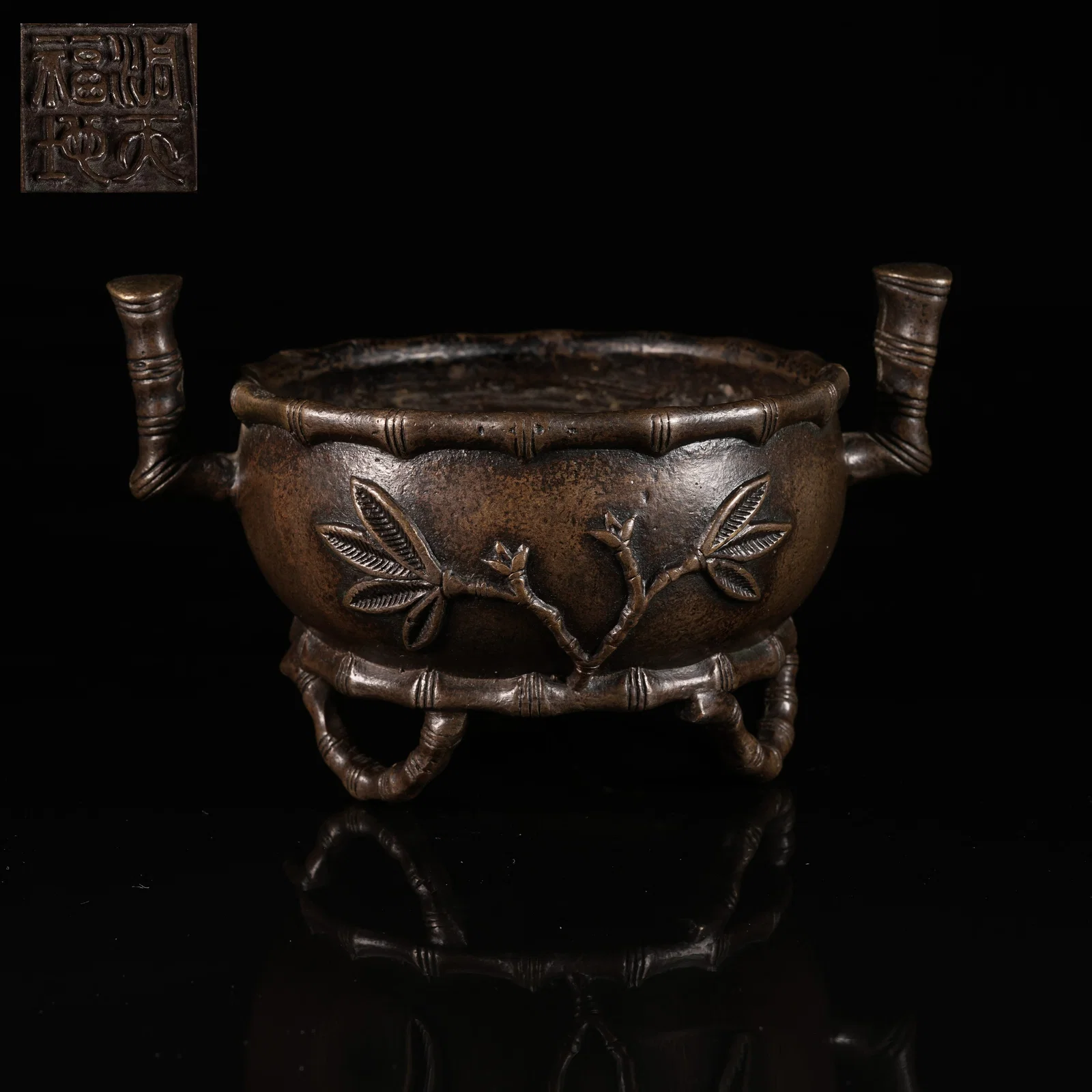 A BRONZE TRIPOD CENSER WITH BAMBOO-FORM LEGS AND UPRIGHT LOOP HANDLES