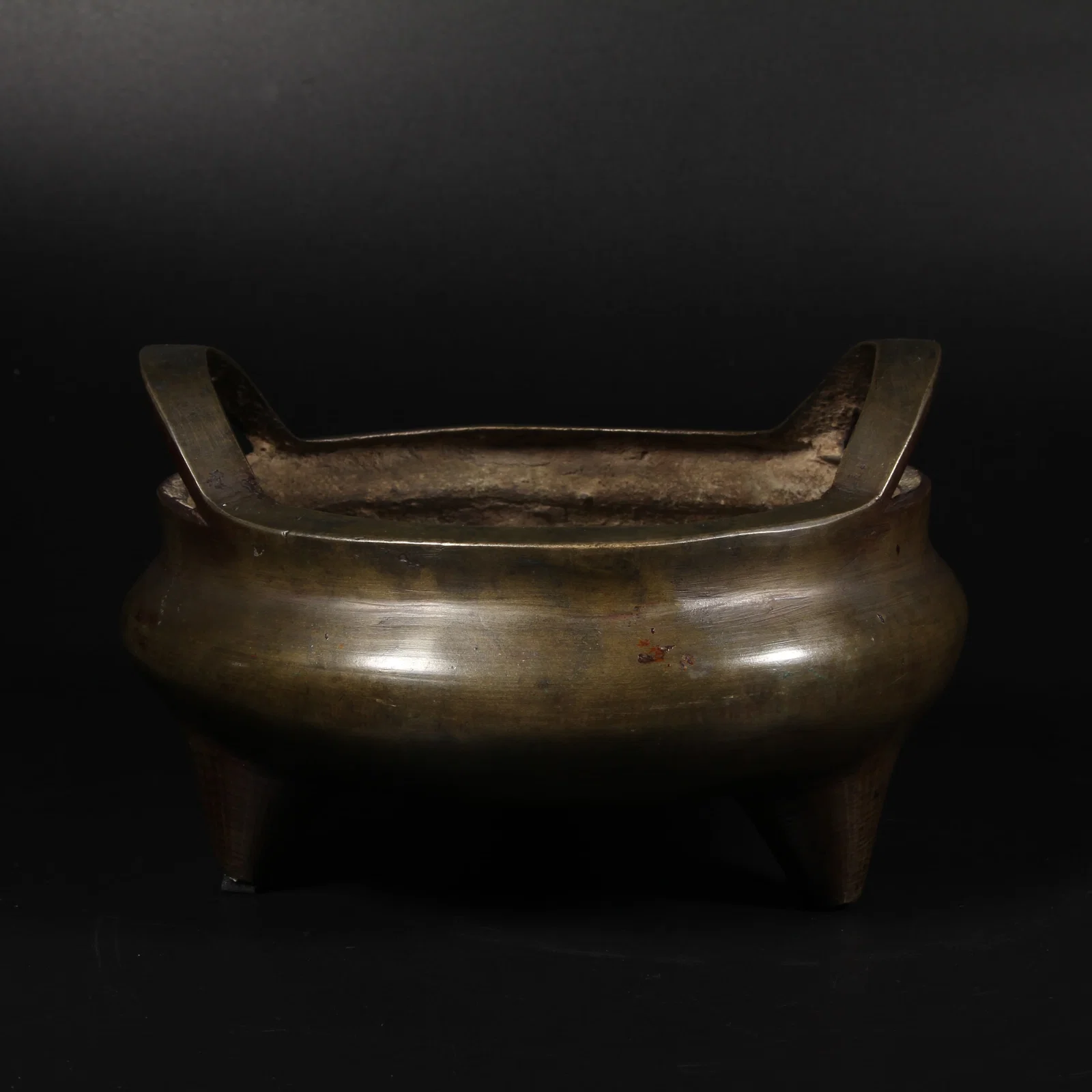A BRONZE TRIPOD CENSER WITH BRIDGE HANDLES