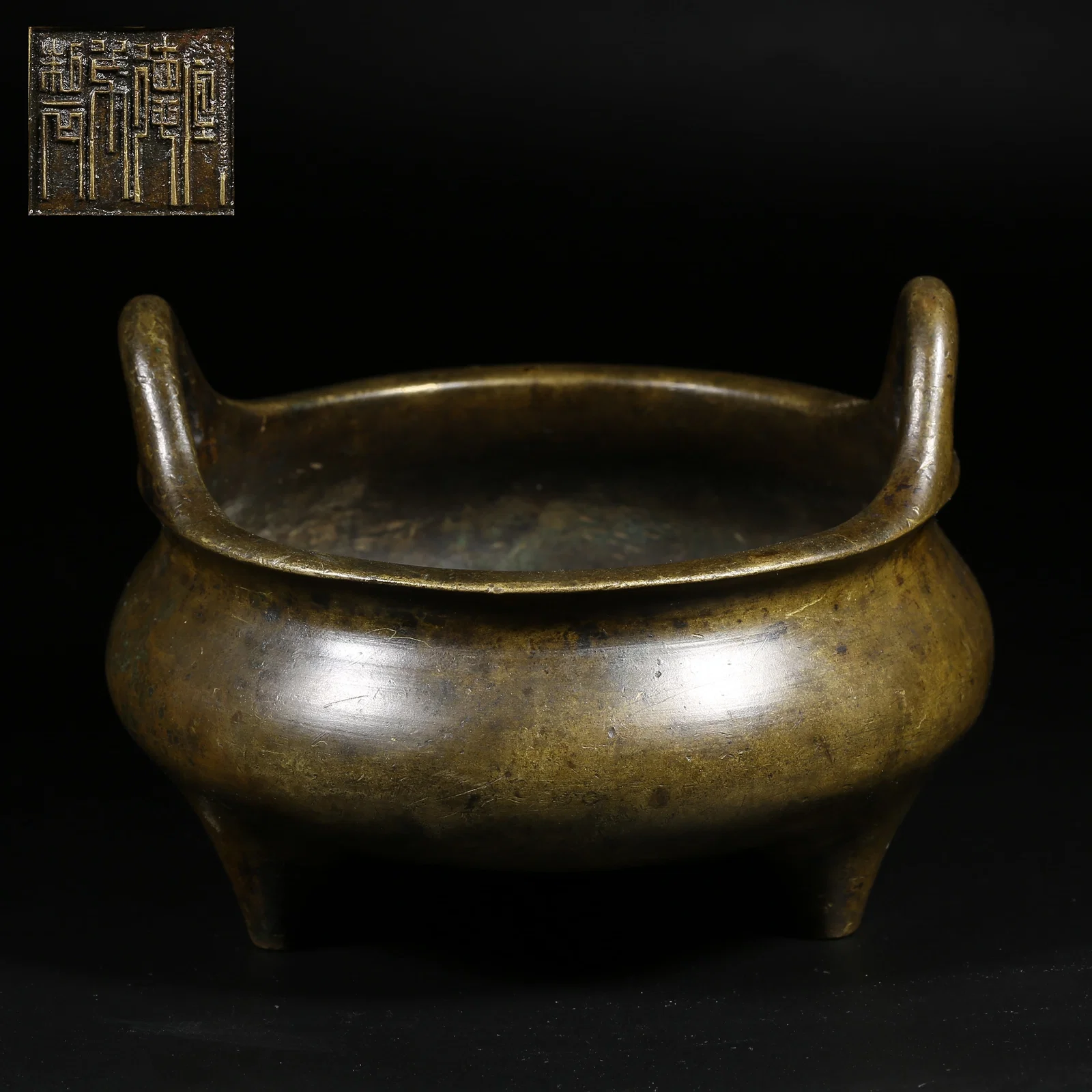 A BRONZE TRIPOD CENSER WITH UPRIGHT HANDLES