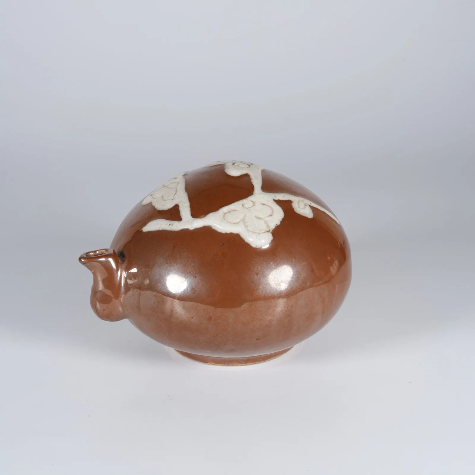 A BROWN-GLAZED INK DROPPER WITH RESERVED PLUM BLOSSOM DESIGN