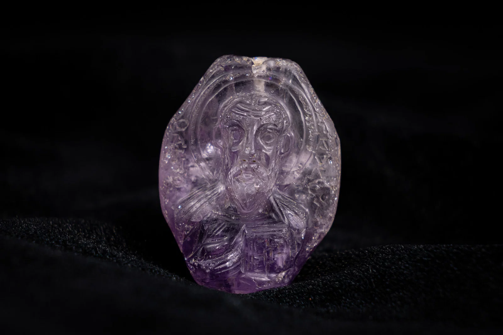 A BYZANTINE OR RUSSIAN DOUBLE-SIDED CARVED AMETHYST ICON PENDANT DEPICTING SAINT NICHOLAS AND SAINT