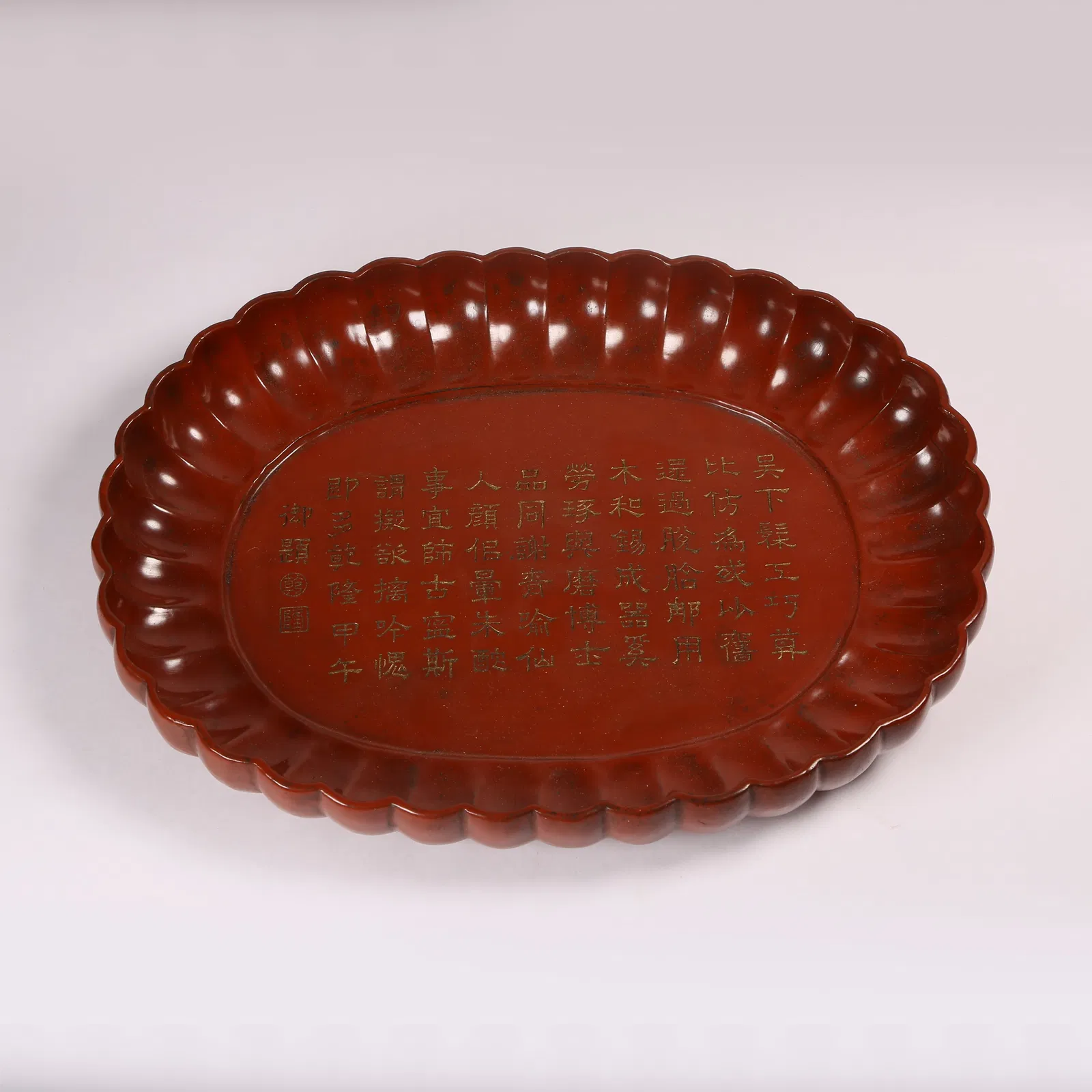 A CARVED RED LACQUER FLOWER-RIMMED DISH WITH IMPERIAL INSCRIPTION