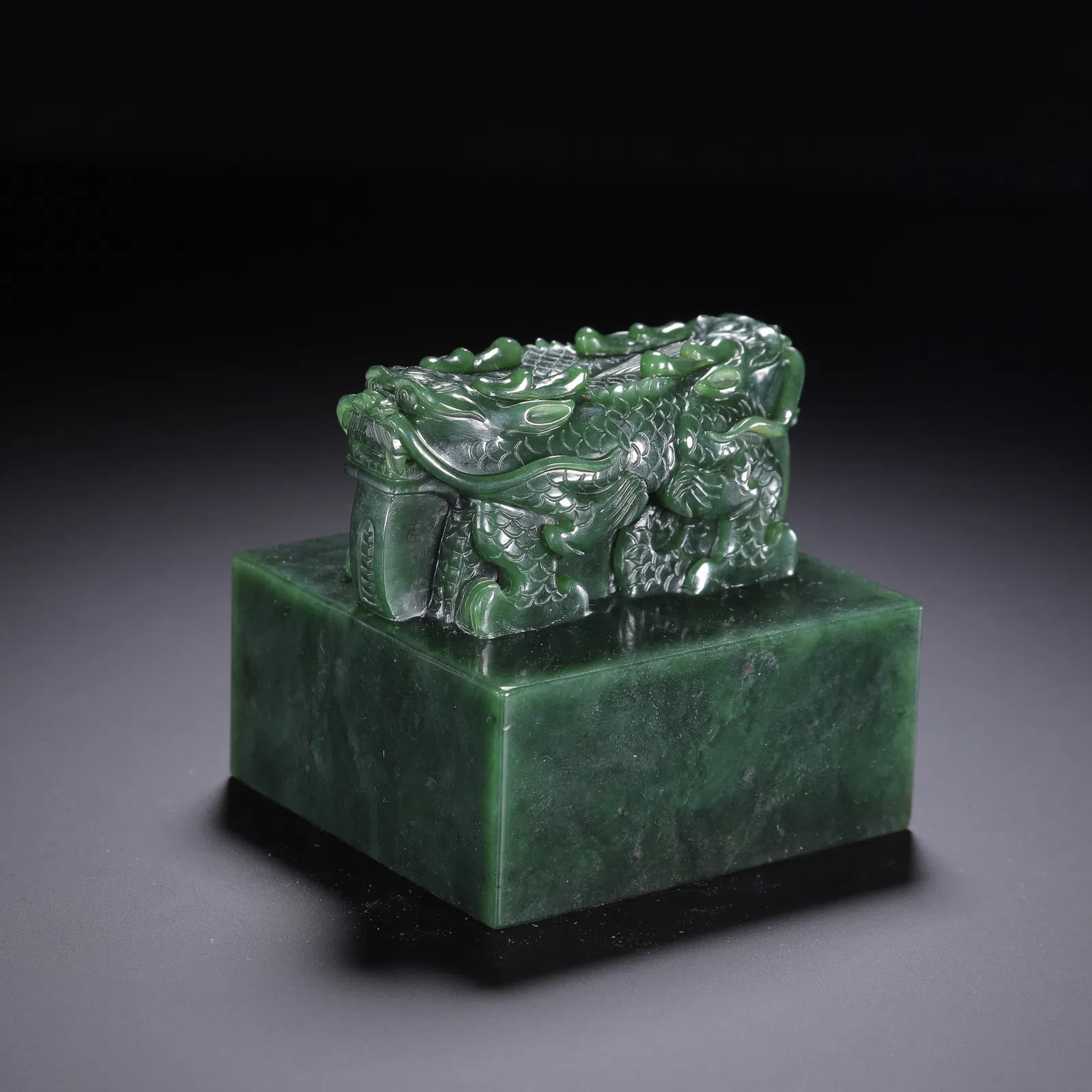 A CARVED SPINACH GREEN JADE DRAGON SEAL