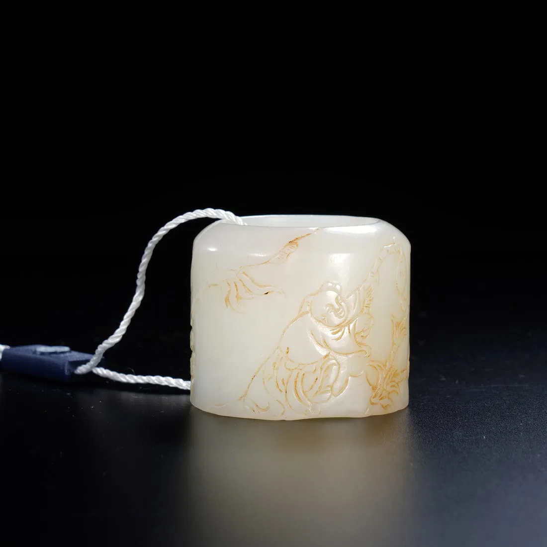 A CARVED WHITE JADE ARCHER RING