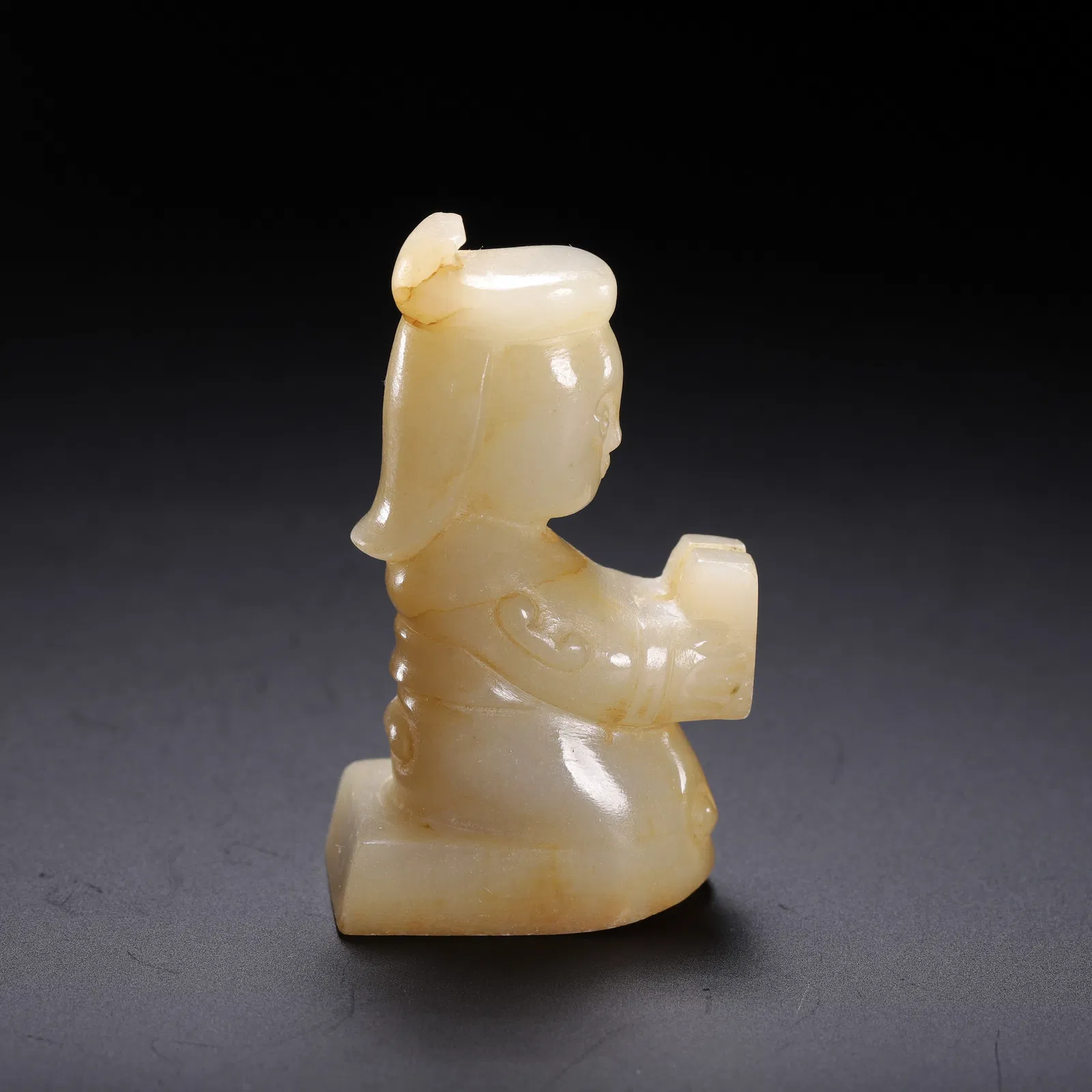 A CARVED WHITE JADE KNEELING FIGURE