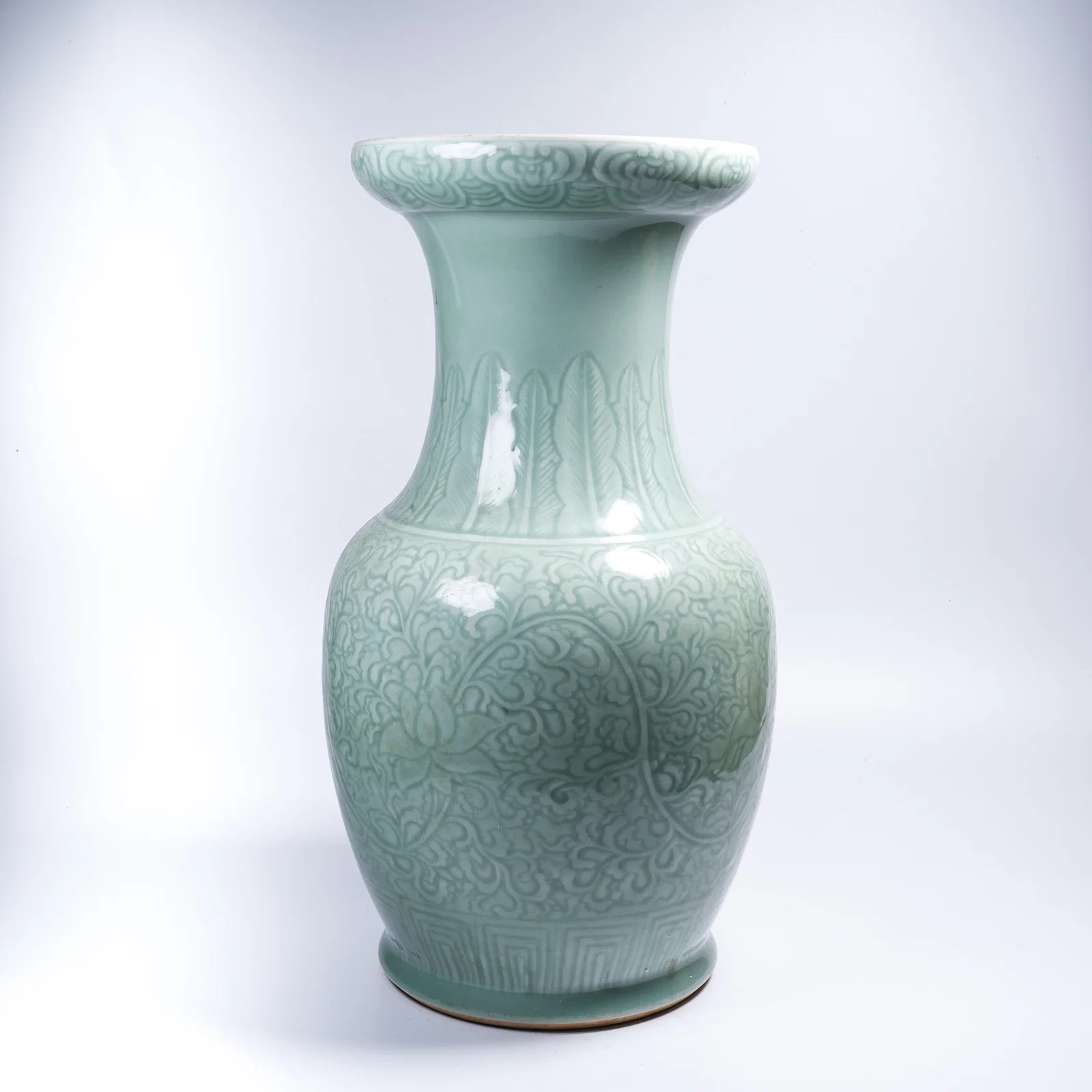 A CELADON-GLAZED ZUN WITH SCROLLING FLORAL DESIGN AND FLARED MOUTH