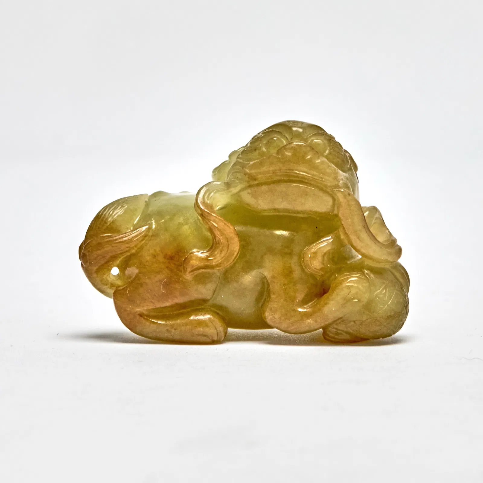A Chinese Celadon Yellow Jade Carving of a Fu Lion