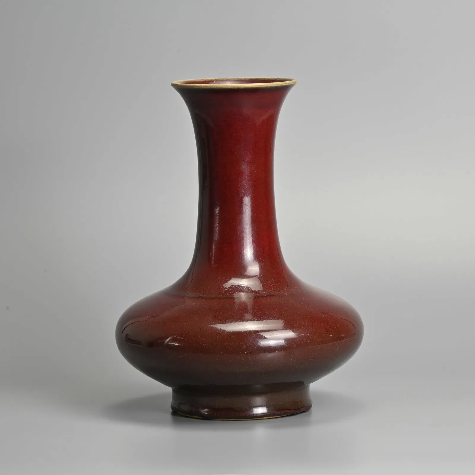 A CHINESE SANG DE BOEUF PORCELAIN BOTTLE VASE, QING DYNASTY.