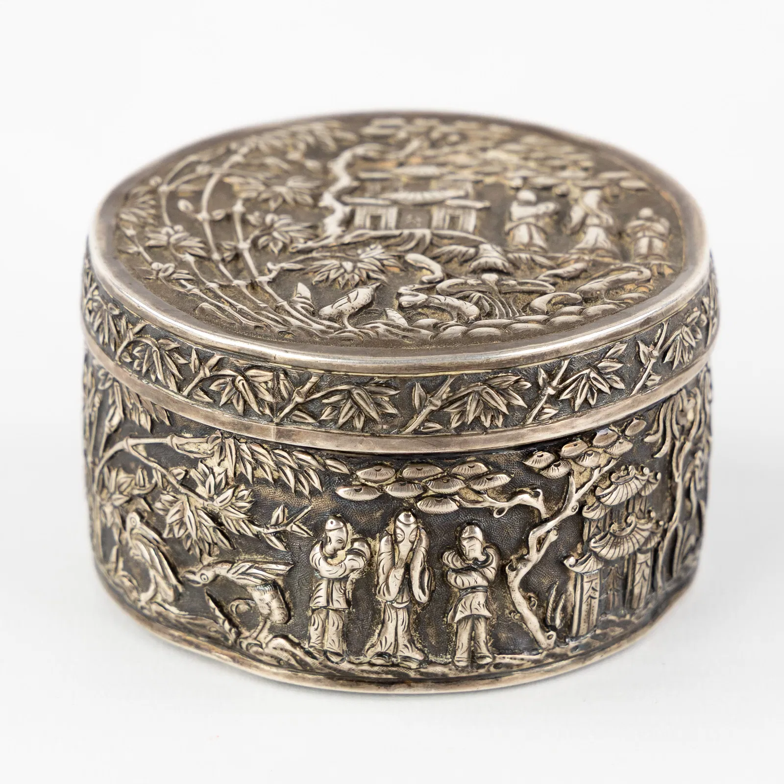 A Chinese silver covered box, decorated with a figurative landscape, circa 1900. Silver, 128g.
