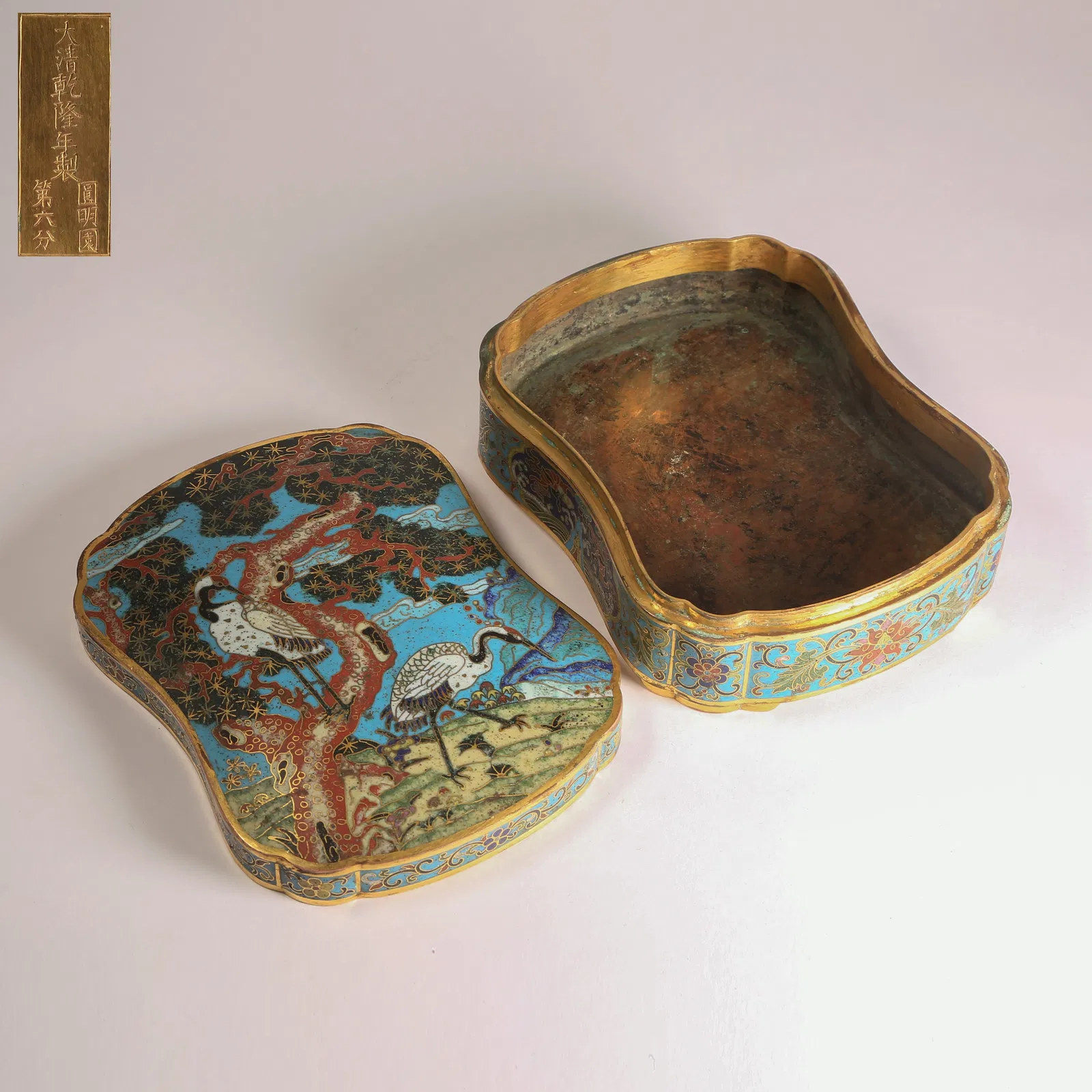 A CLOISONNÉ-ENAMEL COVERED BOX ON BRONZE WITH PINE AND CRANE LONGEVITY MOTIFS