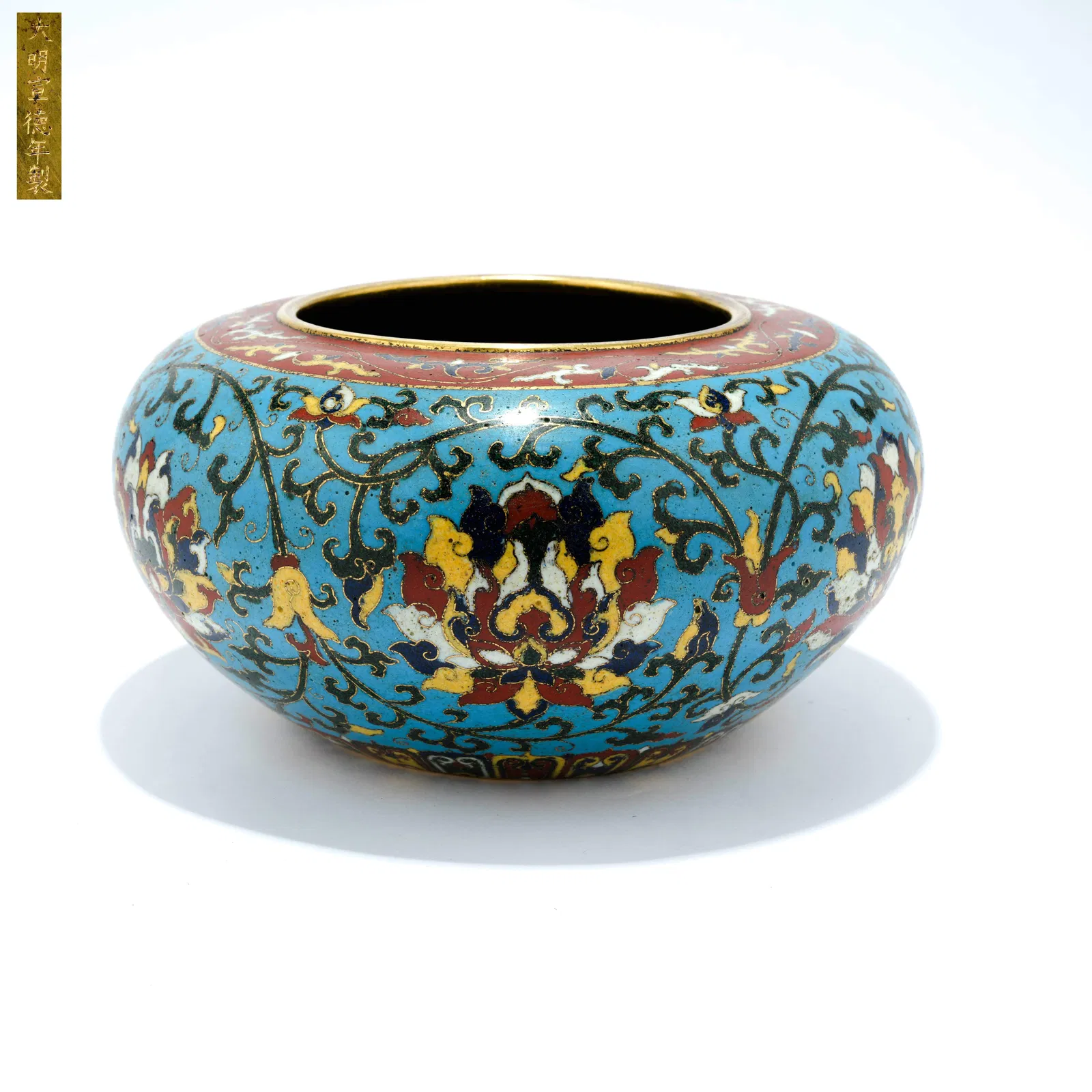 A CLOISONNÉ ENAMEL JAR WITH INTERTWINED FLORAL SCROLL DESIGN ON A BRONZE BODY