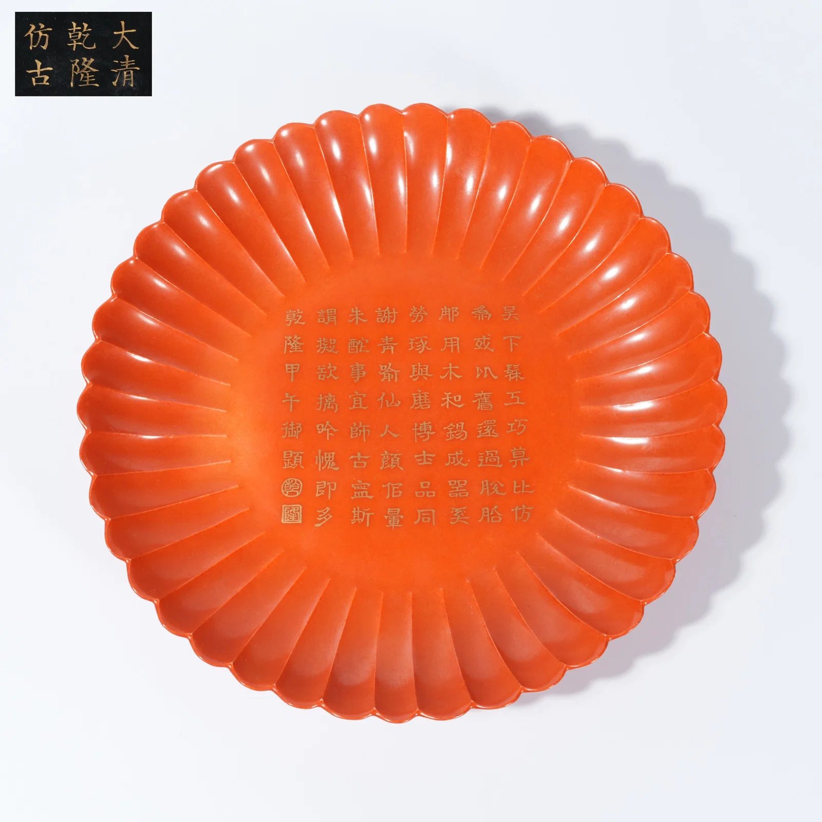 A CORAL-RED-GLAZED CHRYSANTHEMUM-FORM DISH WITH GILDED INCISED POETIC INSCRIPTION