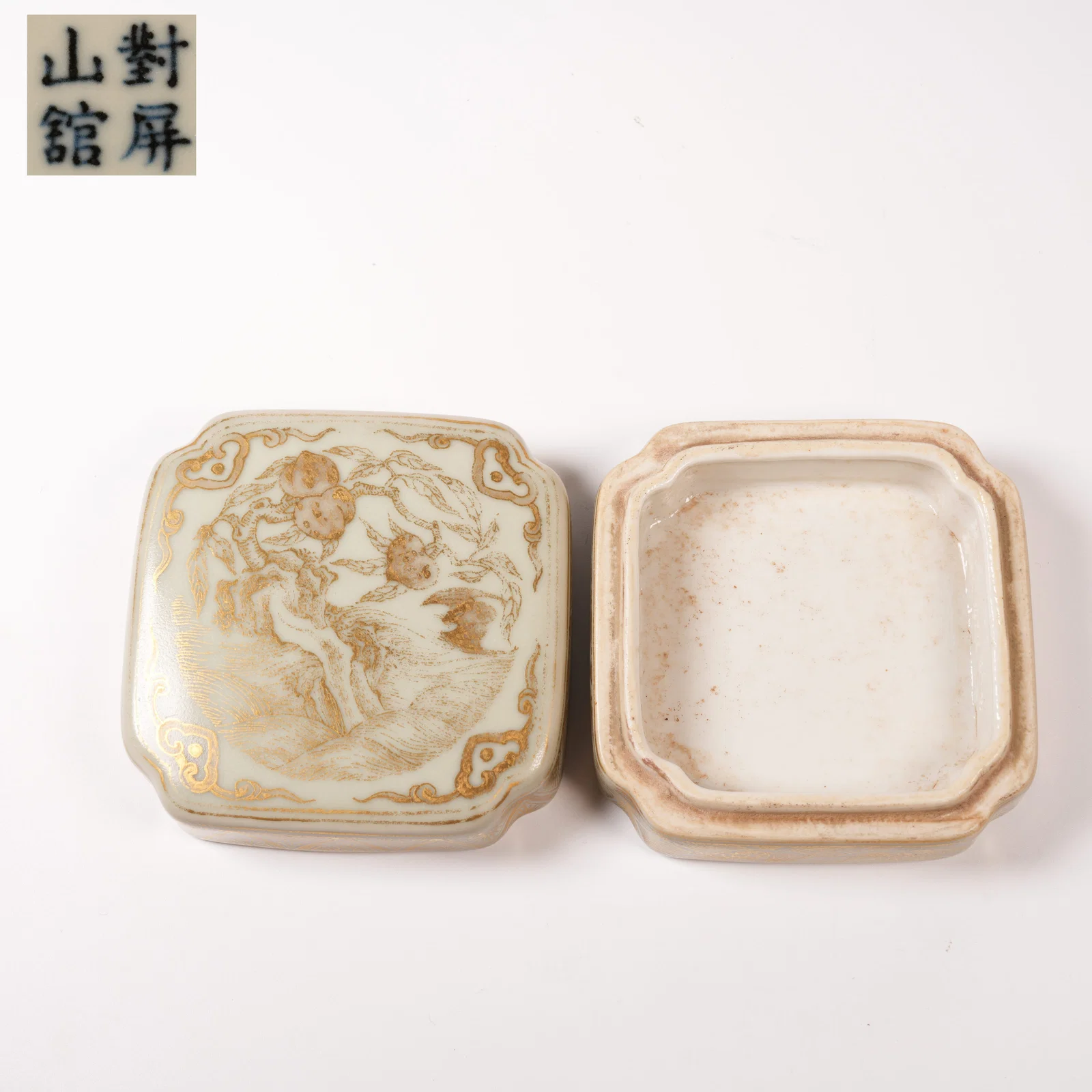 A FAMILLE ROSE-AND-CELADON SQUARE INK PASTE BOX WITH GILT AUSPICIOUS PEACH MOTIF AND CORNER LAPPETS