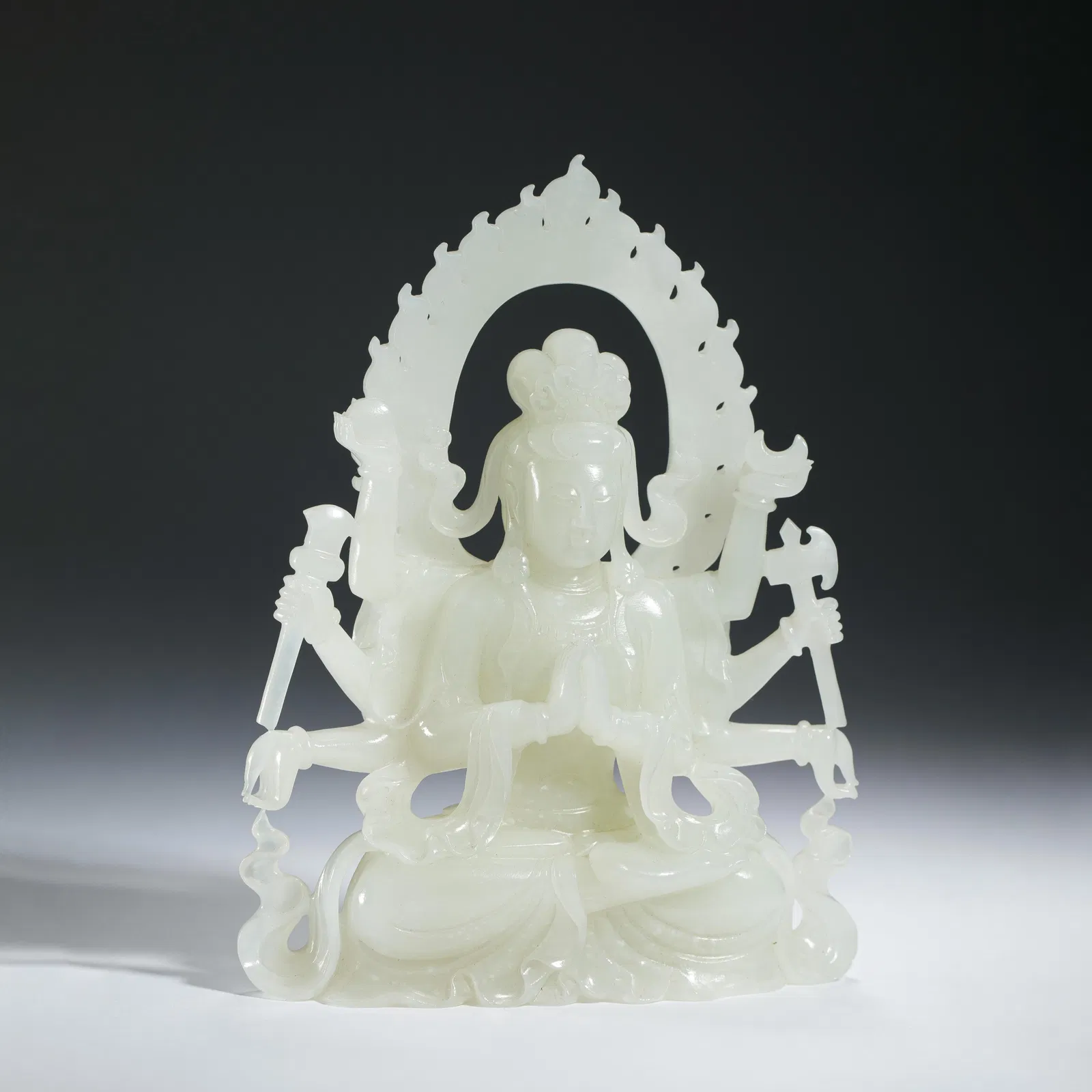 A FINE CARVED WHITE JADE SEATED BODHISATTVA
