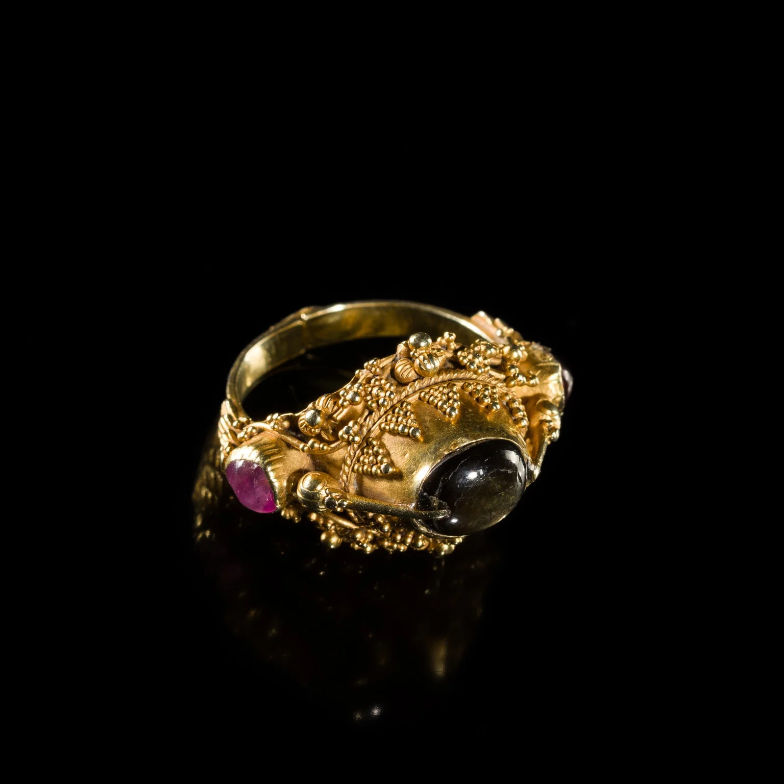 A GEM-SET 21.6K GOLD 'FLOWER AND BIRD' PRIEST'S RING, BALI