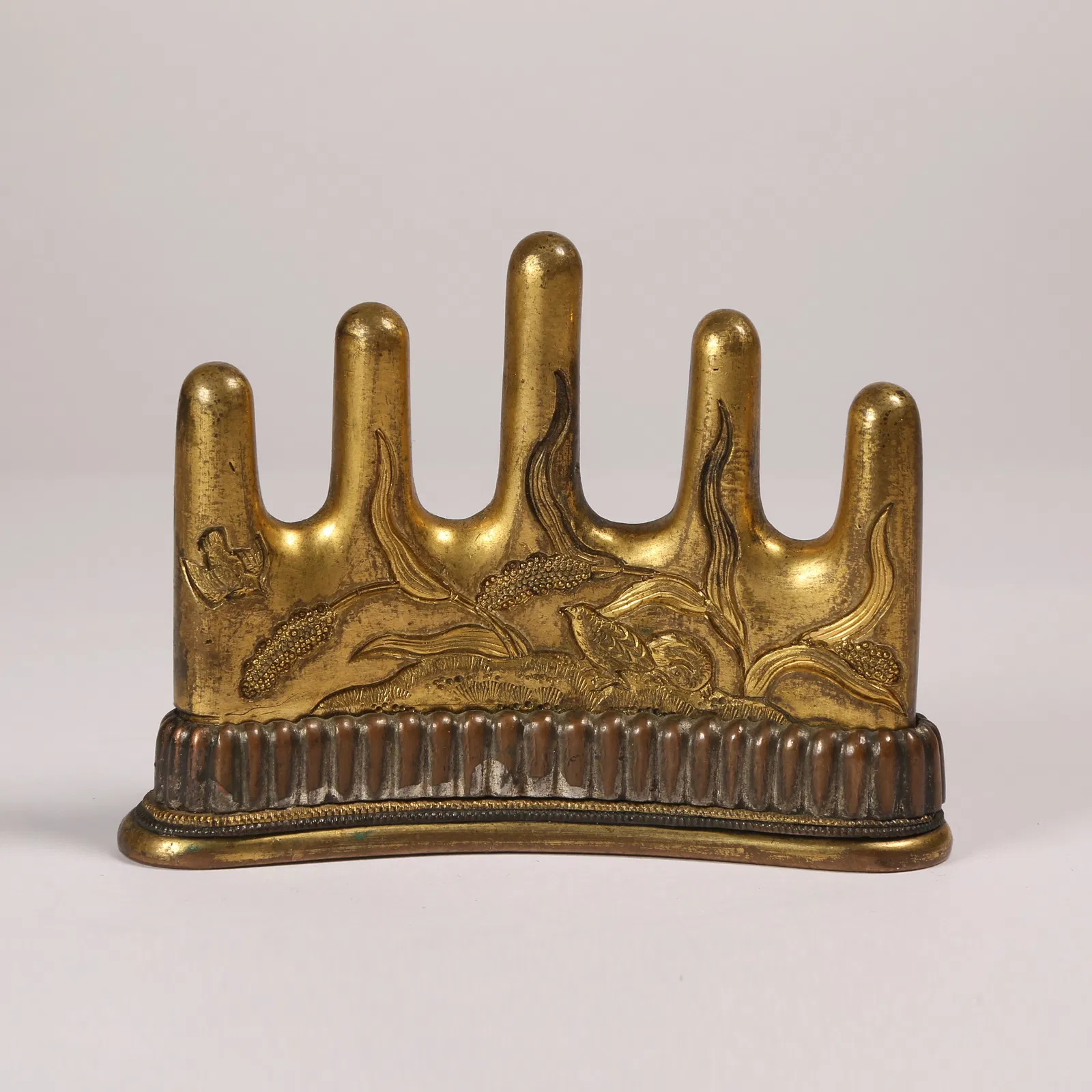 A GILT BRONZE BRUSH REST WITH FLORAL AND BIRD MOTIF
