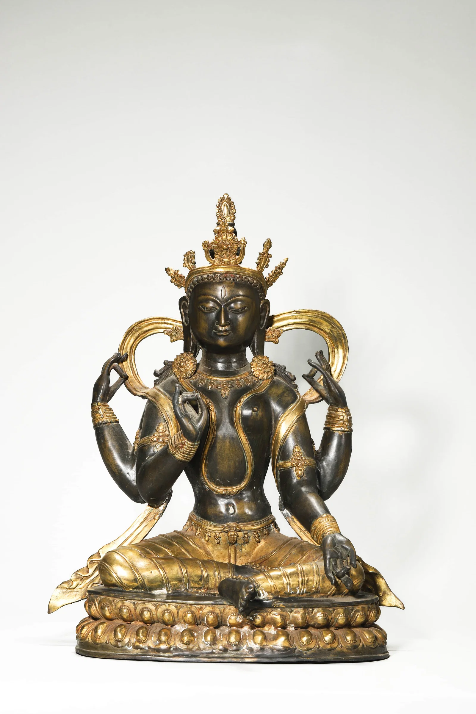 A GILT-BRONZE FOUR-ARMED GUANYIN.