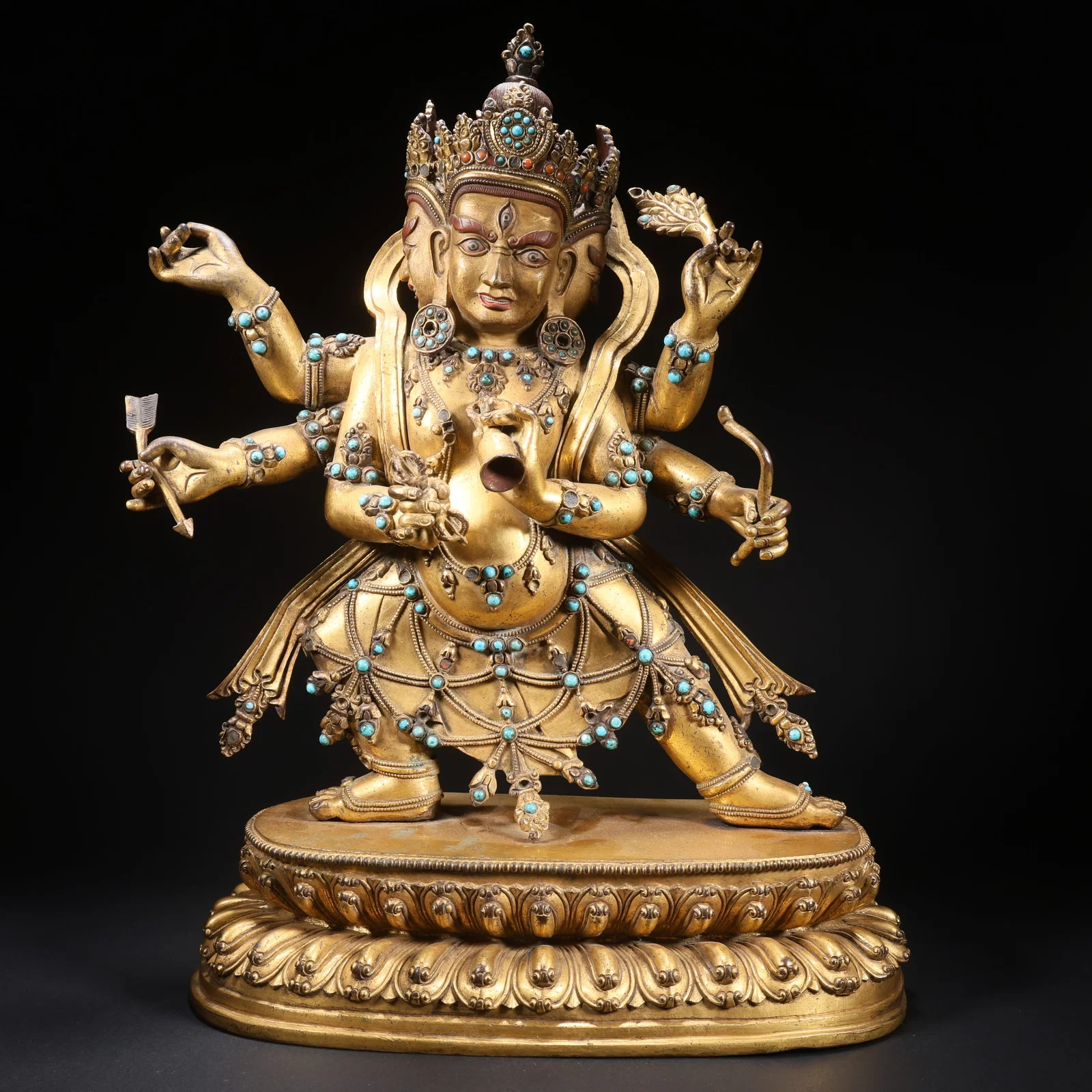 A GILT-BRONZE, GEM-INLAID DHARMA PROTECTOR STATUE WITH THREE HEADS AND SIX ARMS