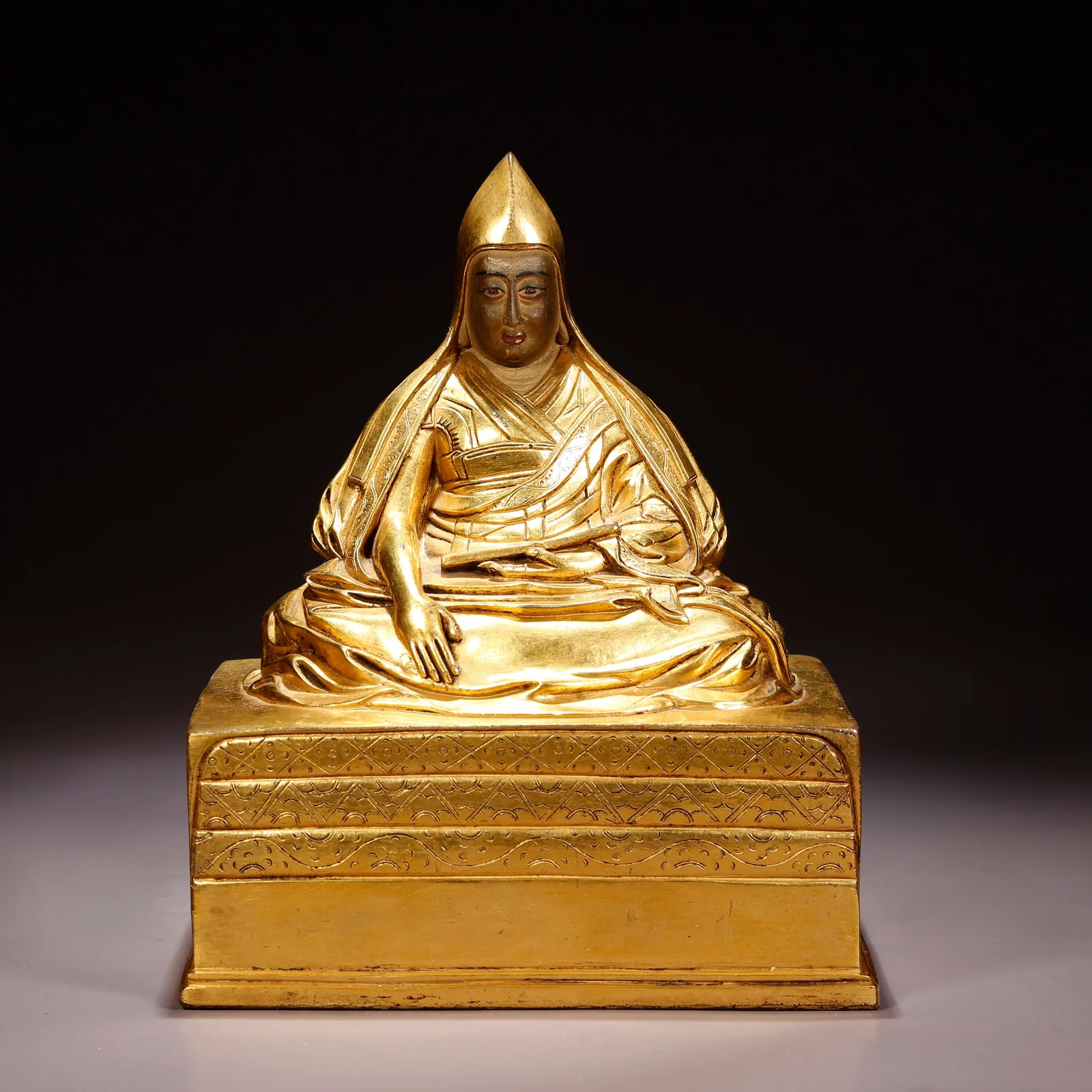 A GILT-BRONZE LAMA FIGURE