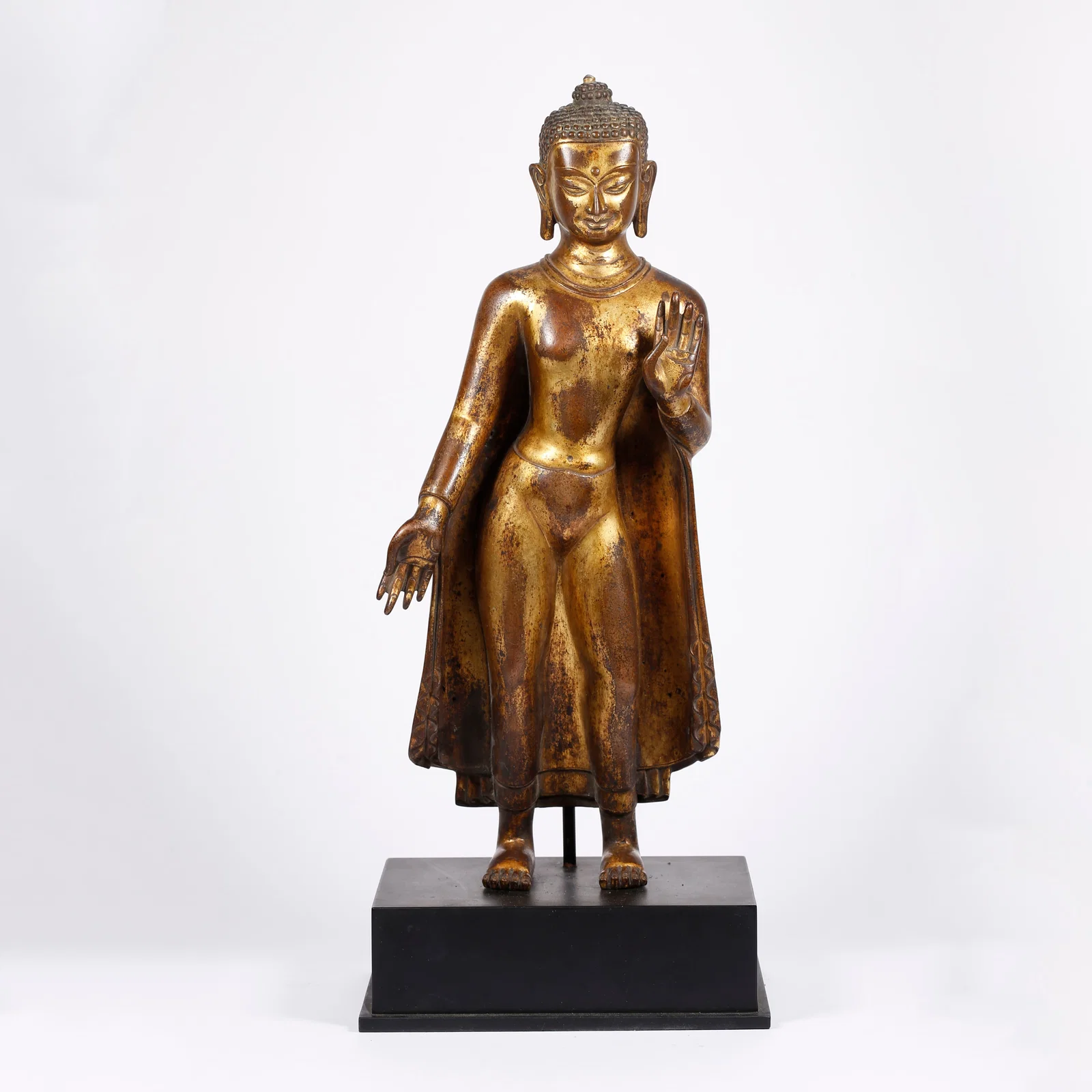 A GILT BRONZE STANDING BUDDHA STATUE