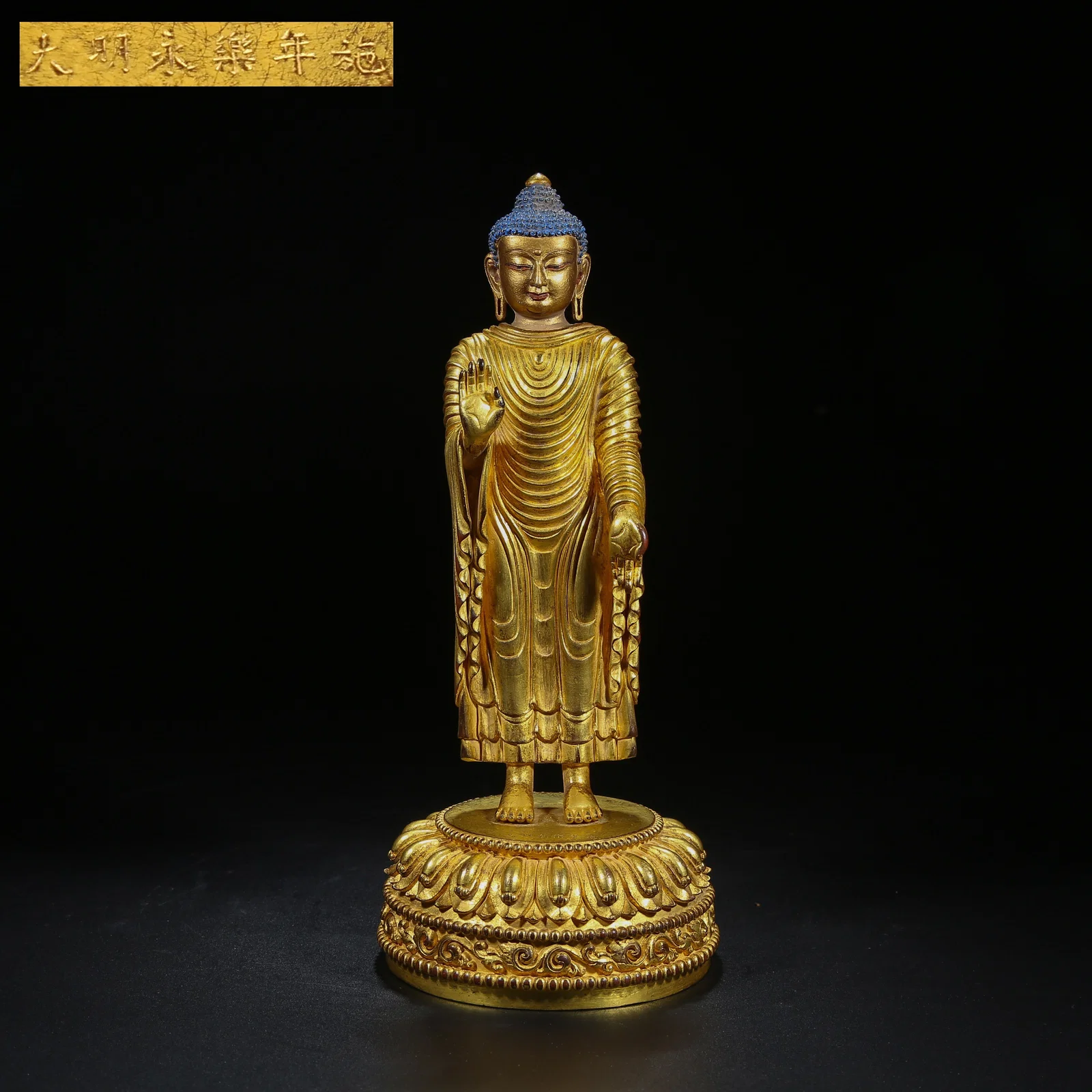 A GILT BRONZE STANDING GUIDING BUDDHA STATUE