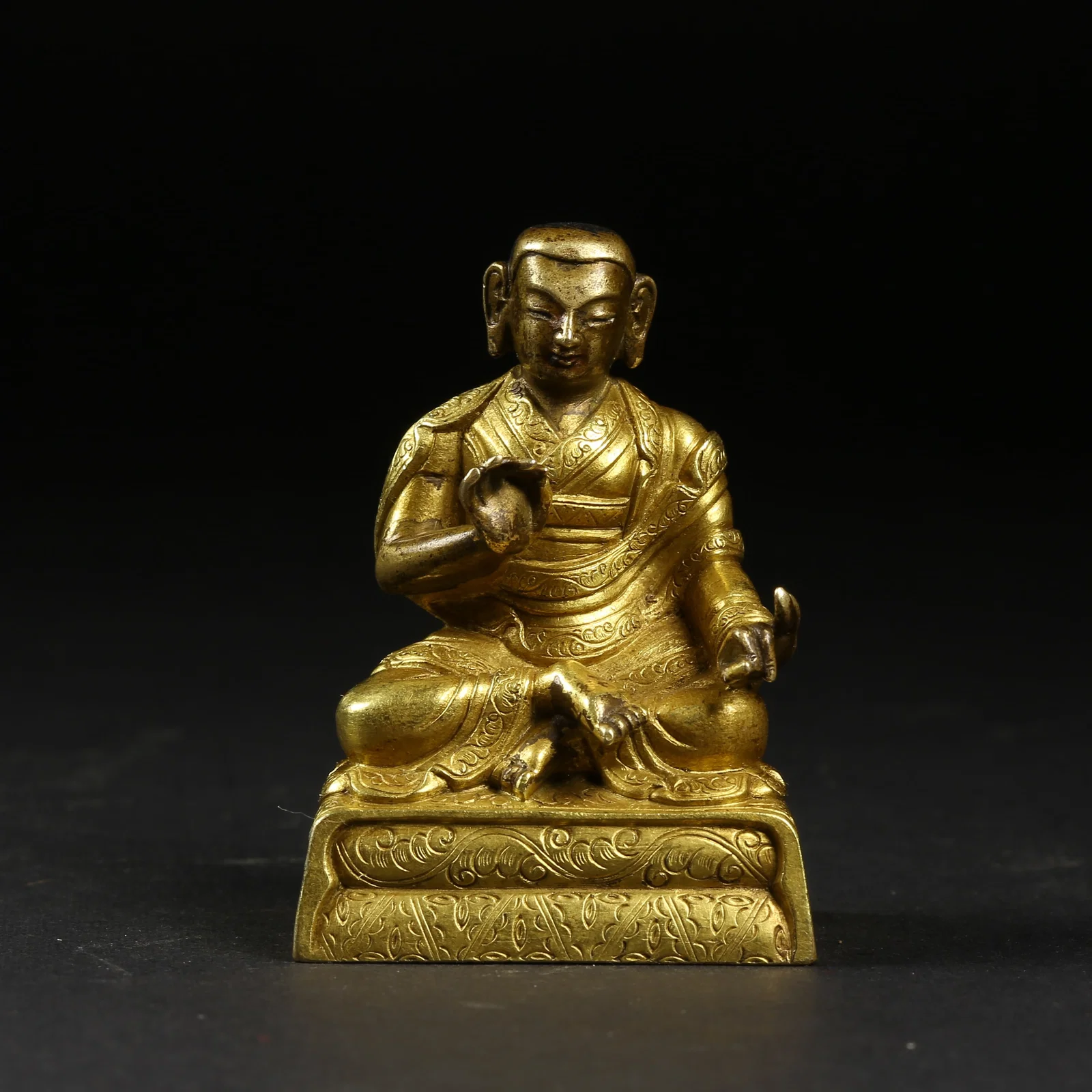 A GILT-BRONZE TEACHER FIGURE (SMALL BUDDHA)