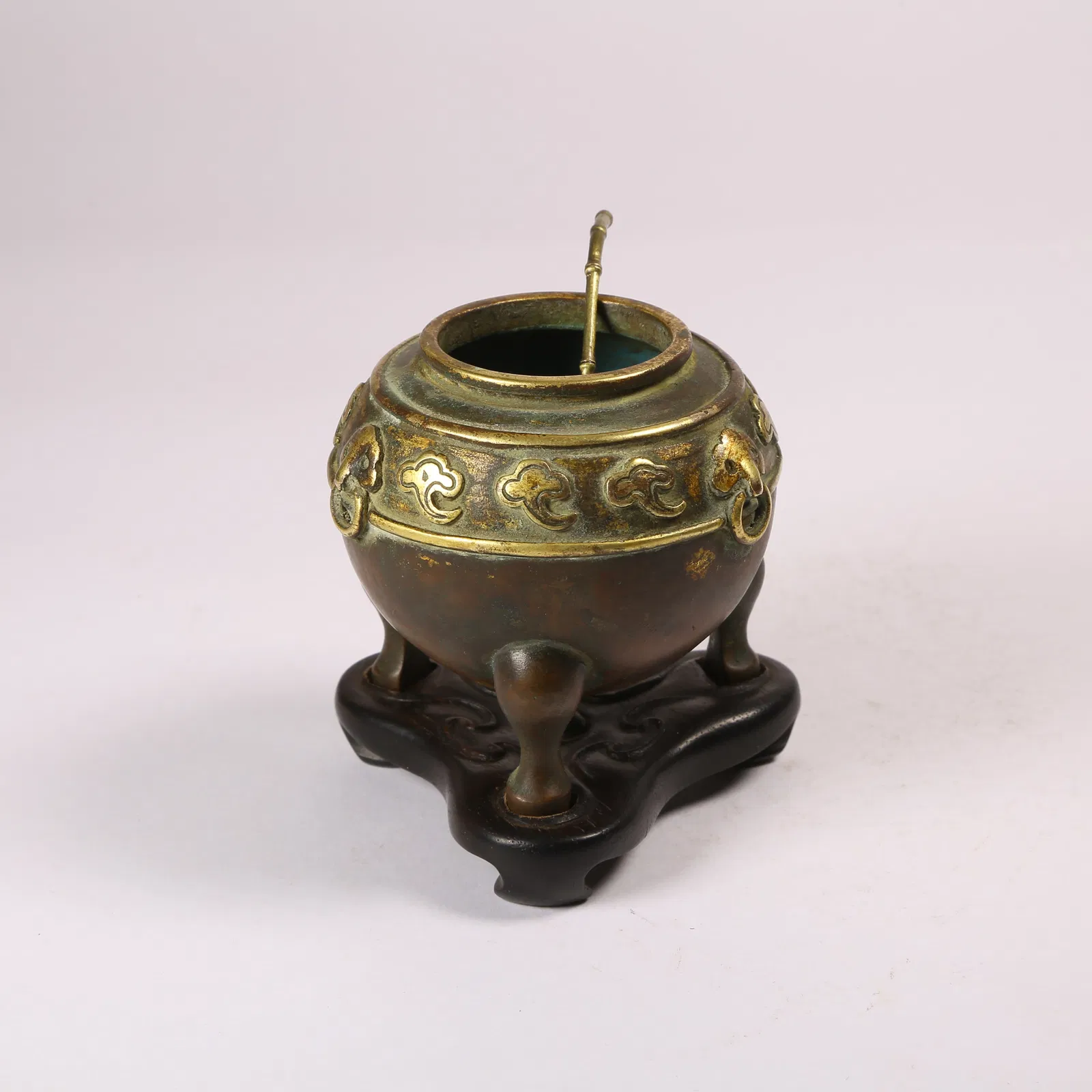 A GILT BRONZE TRIPOD WATER CONTAINER WITH FU-HEADED HANDLES AND AUSPICIOUS CLOUD MOTIF