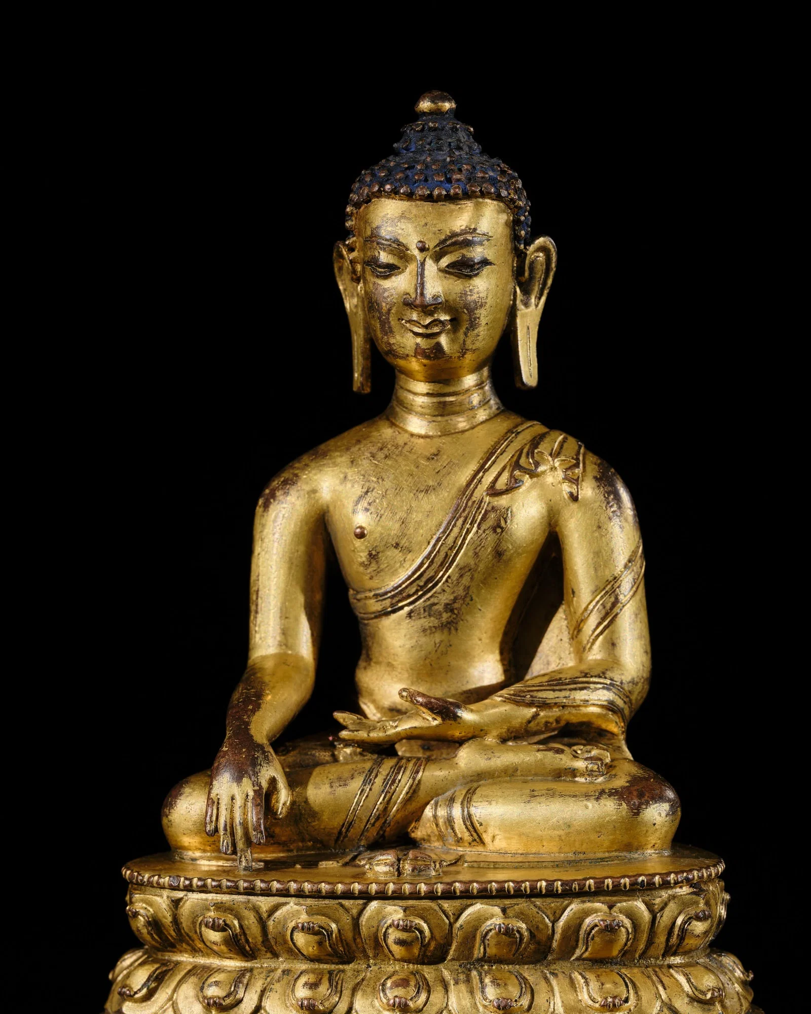 A GILT COPPER ALLOY FIGURE OF BUDDHA VAJRASANA, TIBET, 15TH CENTURY