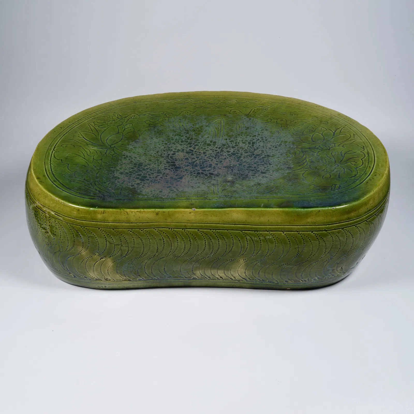 A GREEN-GLAZED PORCELAIN PILLOW WITH FLOWER-AND-BIRD MOTIF