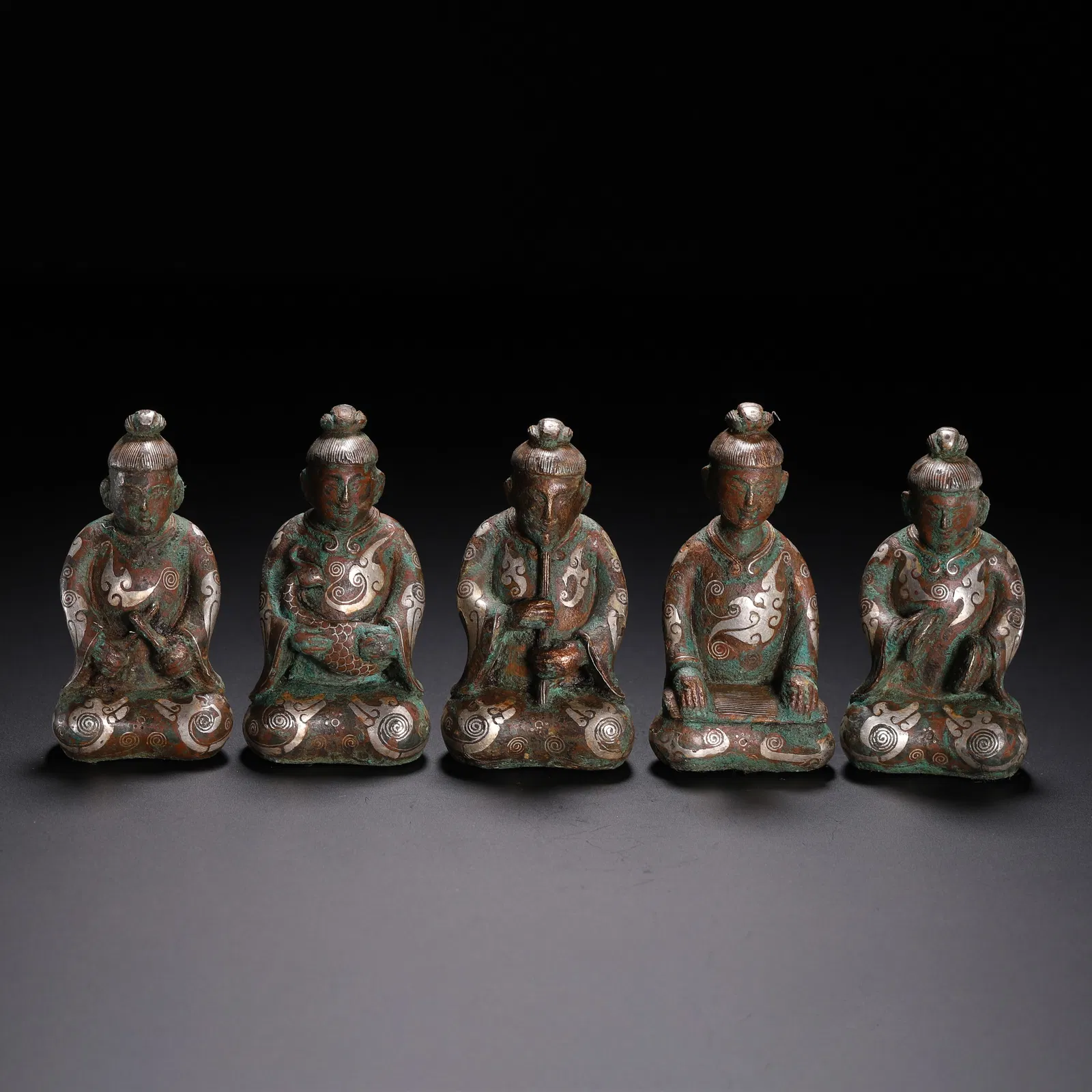 A GROUP OF SILVER INLAID KNEELING FIGURES