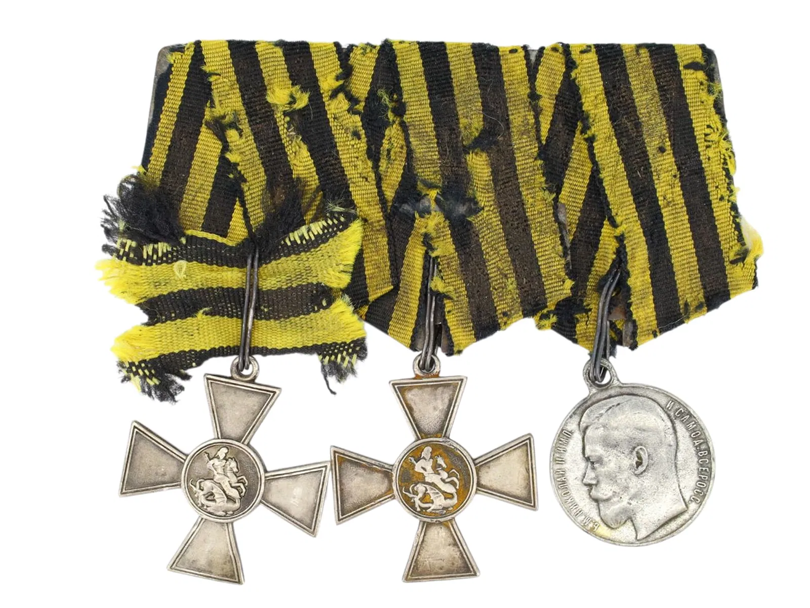 A GROUP OF THREE IMPERIAL RUSSIAN MILITARY AWARDS MOUNTED TOGETHER ON A STEEL BAR