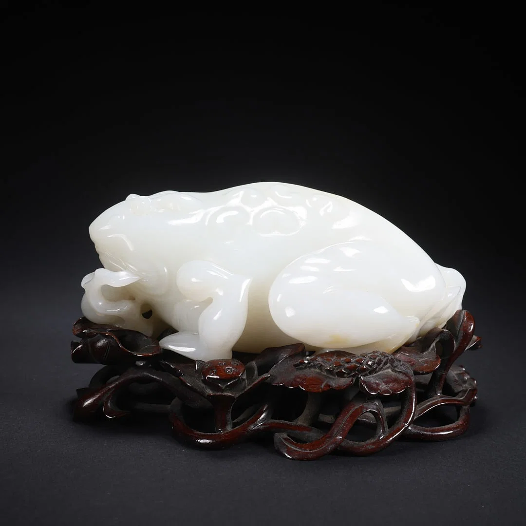 A HETIAN JADE "GOLDEN TOAD" ORNAMENT ON WOODEN BASE