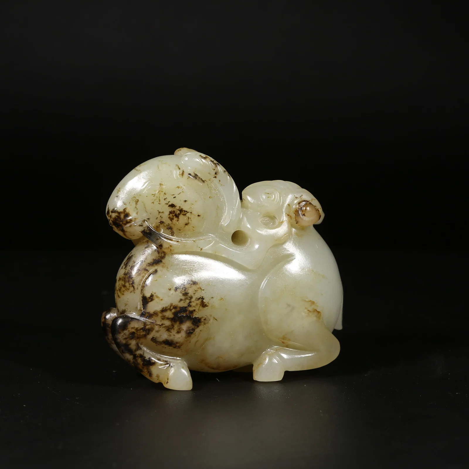 A HETIAN JADE RECLINING SHEEP HOLDING A BRANCH