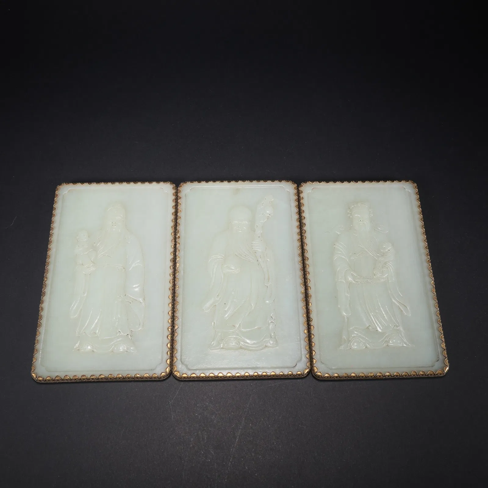 A HETIAN JADE SET OF FULU SHOU (BLESSING, PROSPERITY, LONGEVITY) JADE PLAQUES WITH GOLD TRIM